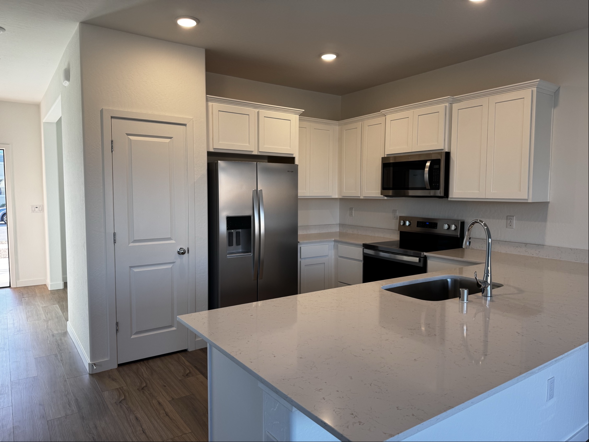 A kitchen with white cabinets.