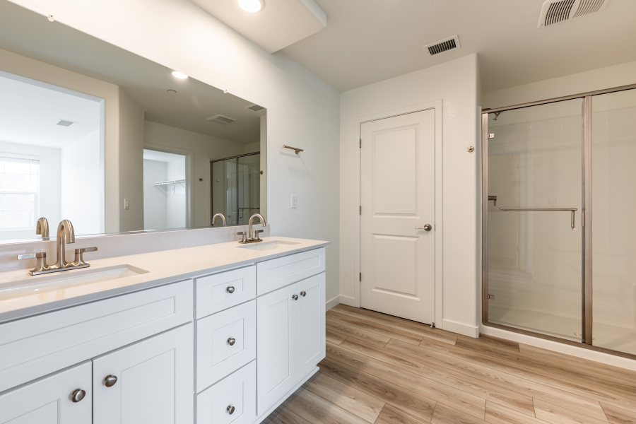 A bathroom with white cabinets.