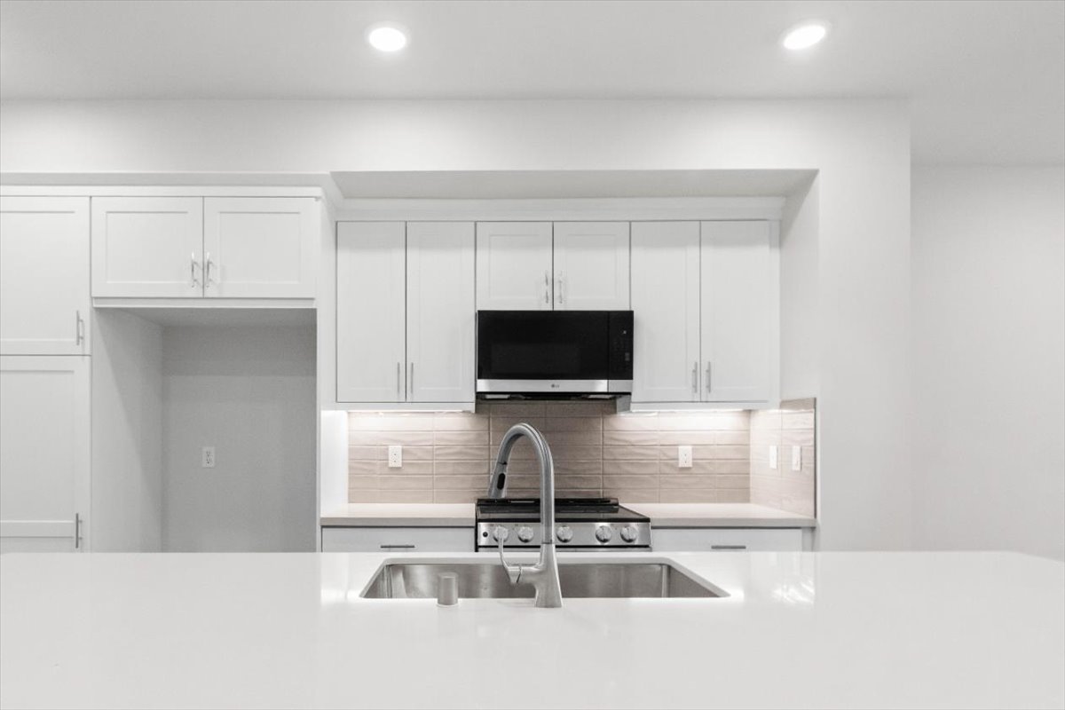 A kitchen with white cabinets.