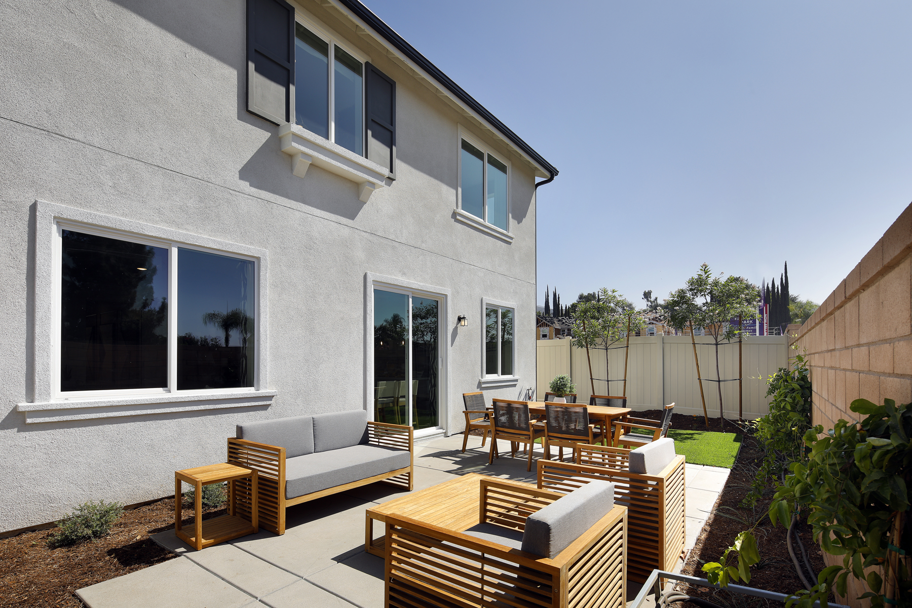 A patio with chairs and tables outside a house.