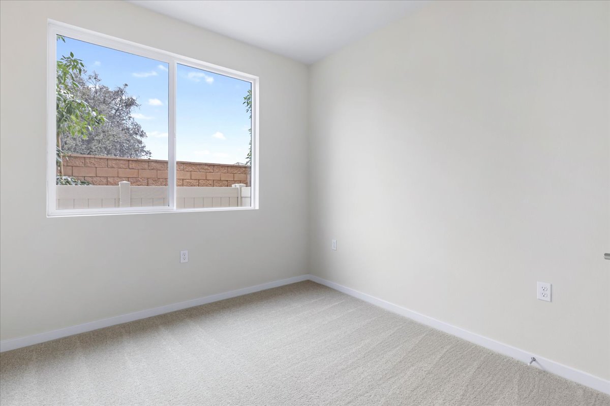 A room with a window and a white wall.