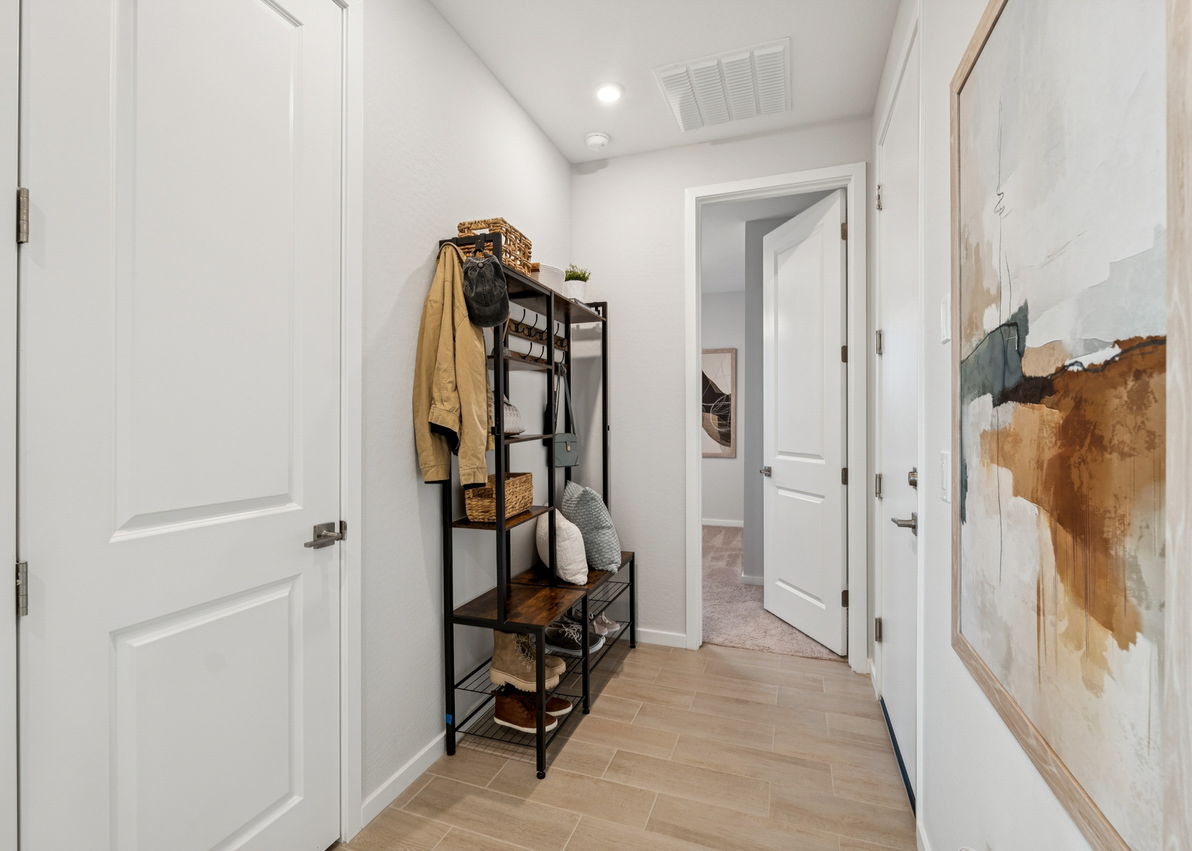 A room with white doors and a wood chair with a blanket on it.