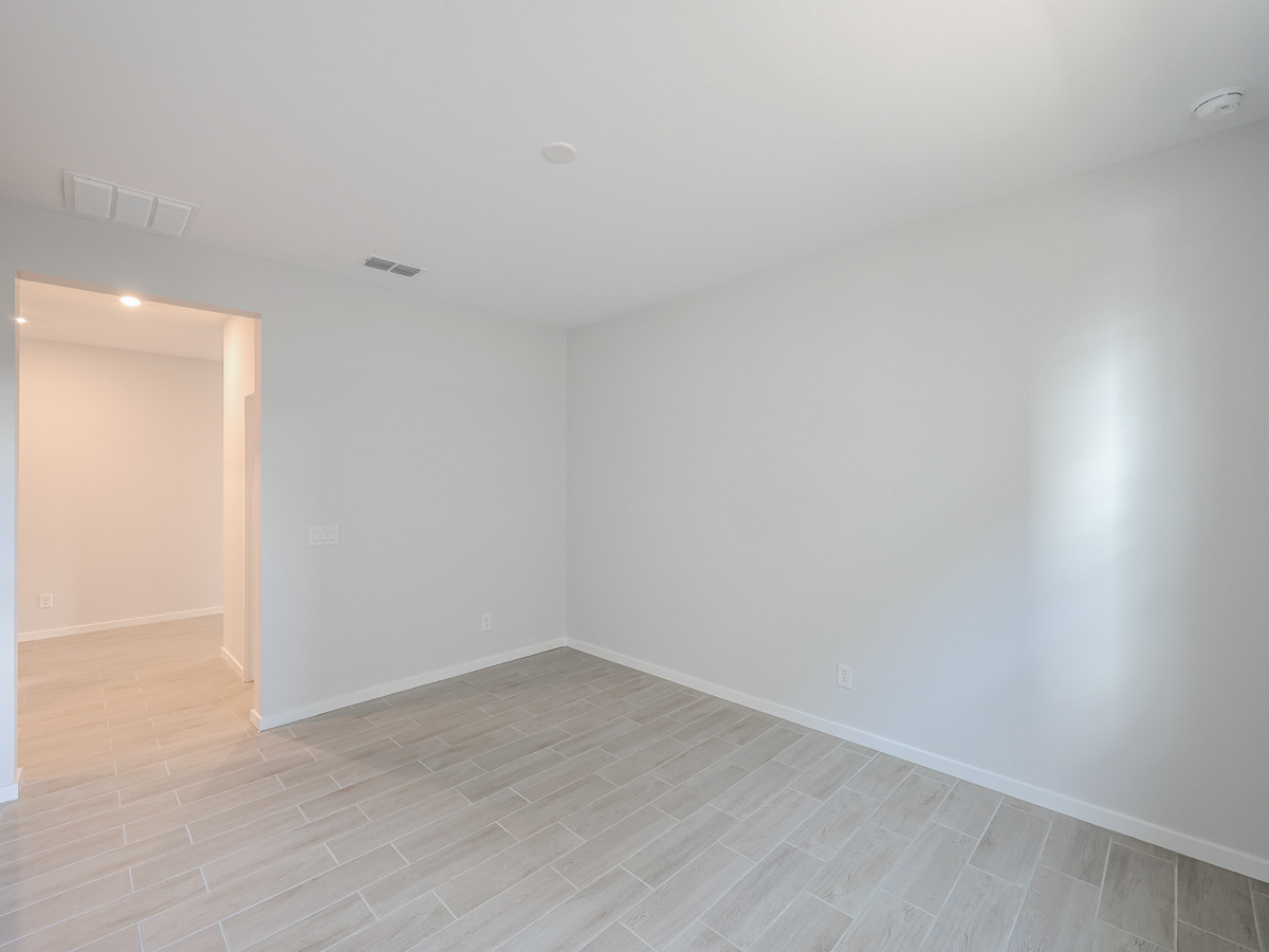 A room with a white wall and a wood floor.