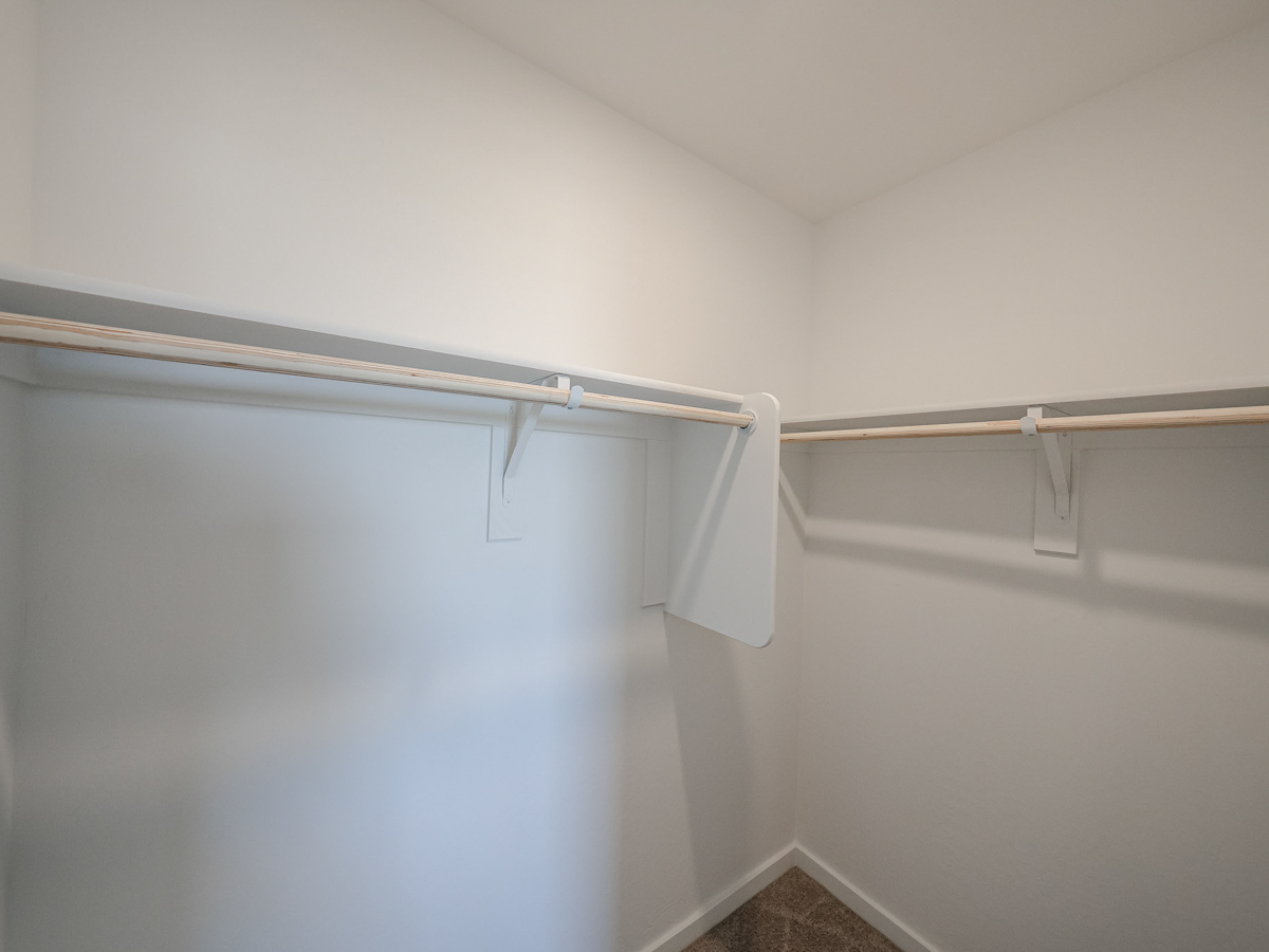 A white wall with a metal bar.