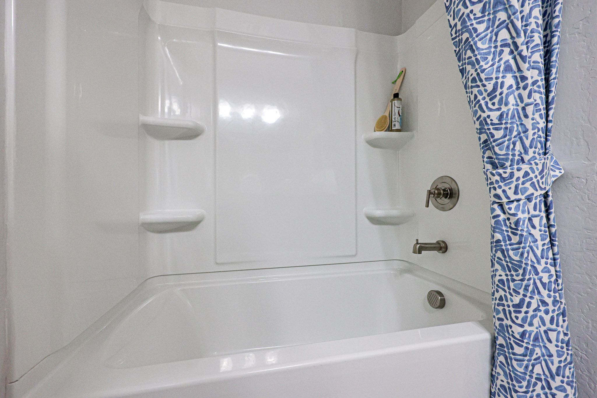 A bathroom with a bathtub and shower curtain.