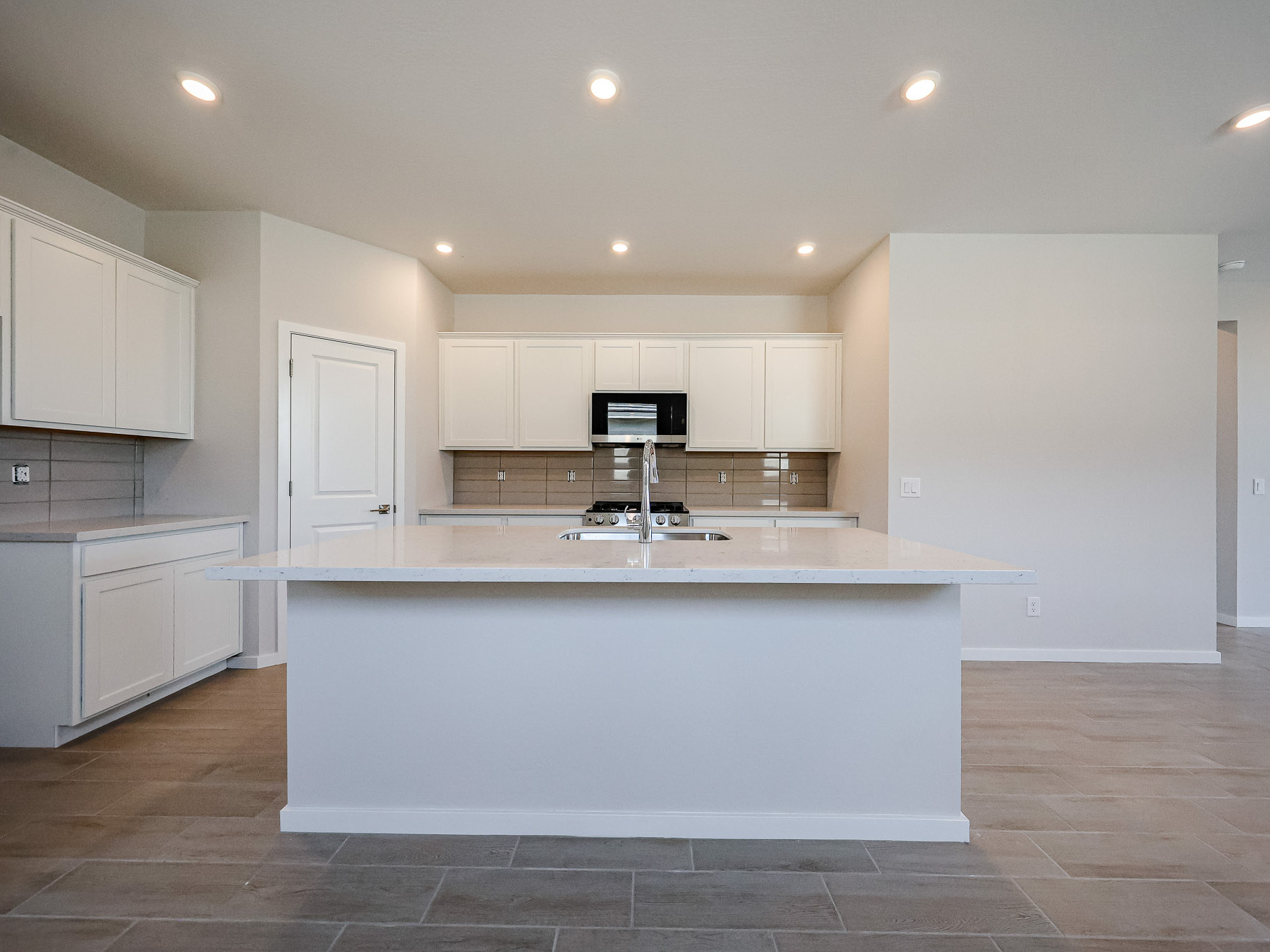 A kitchen with white cabinets.
