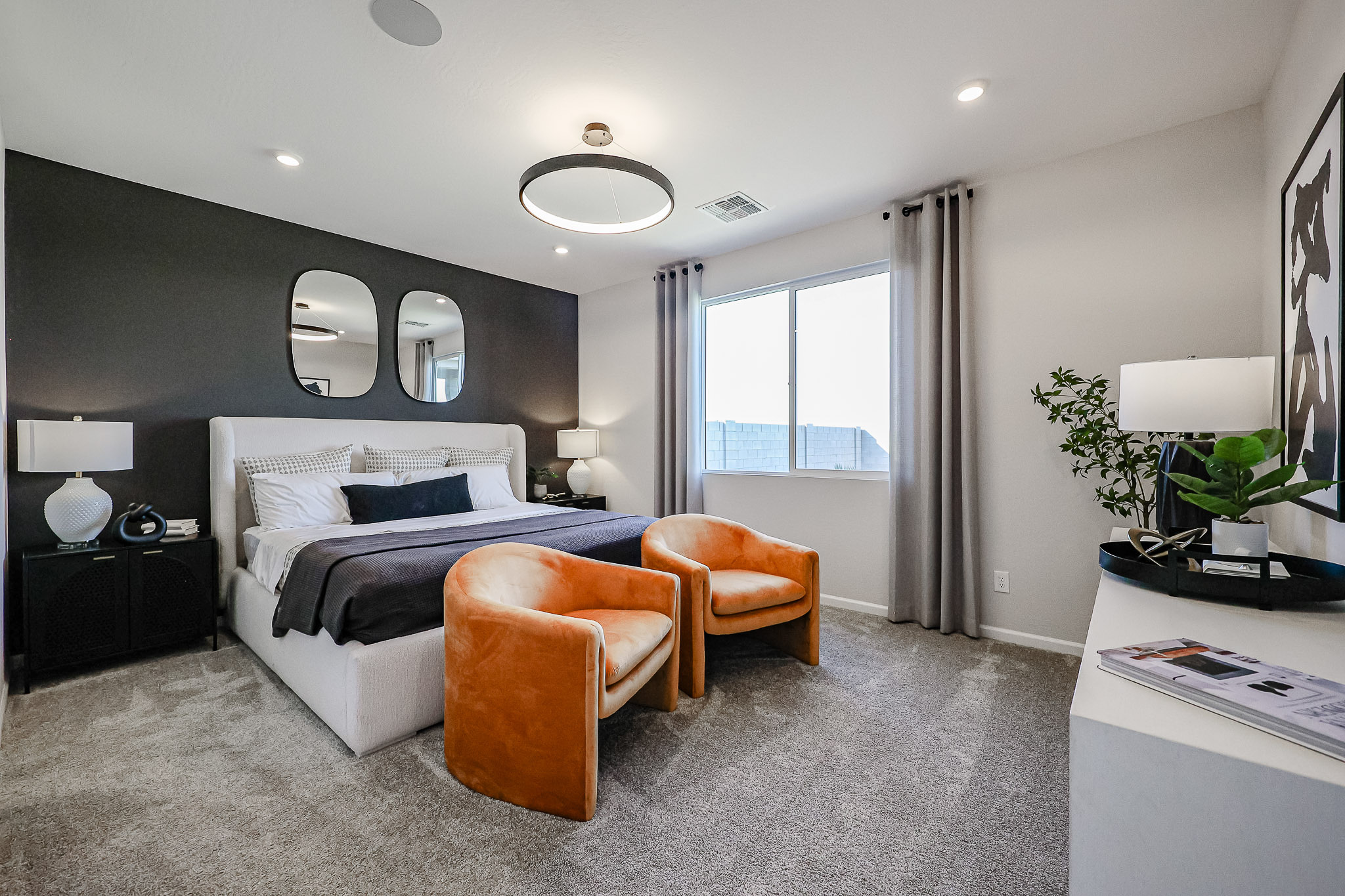 A bedroom with a bed and chairs.