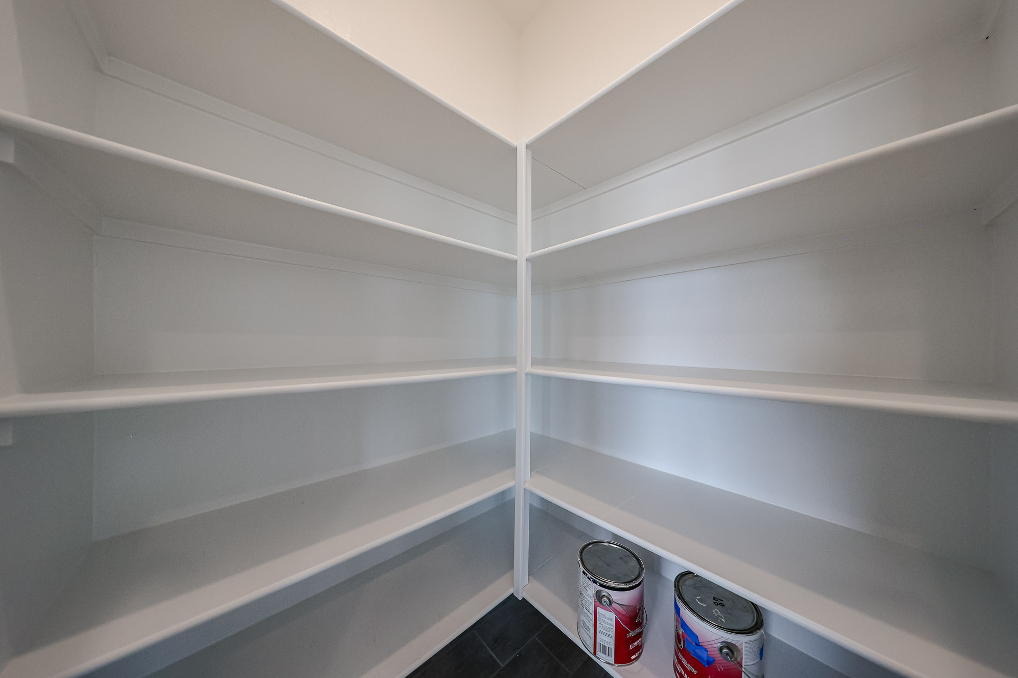 A white shelf with white walls.
