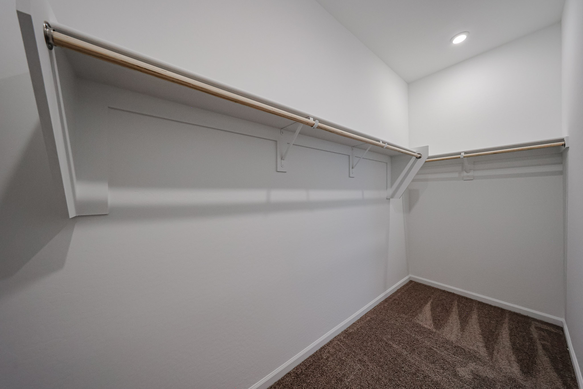 A white wall with a metal bar.