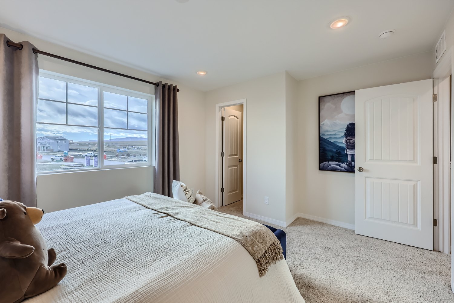 A bedroom with a large window.