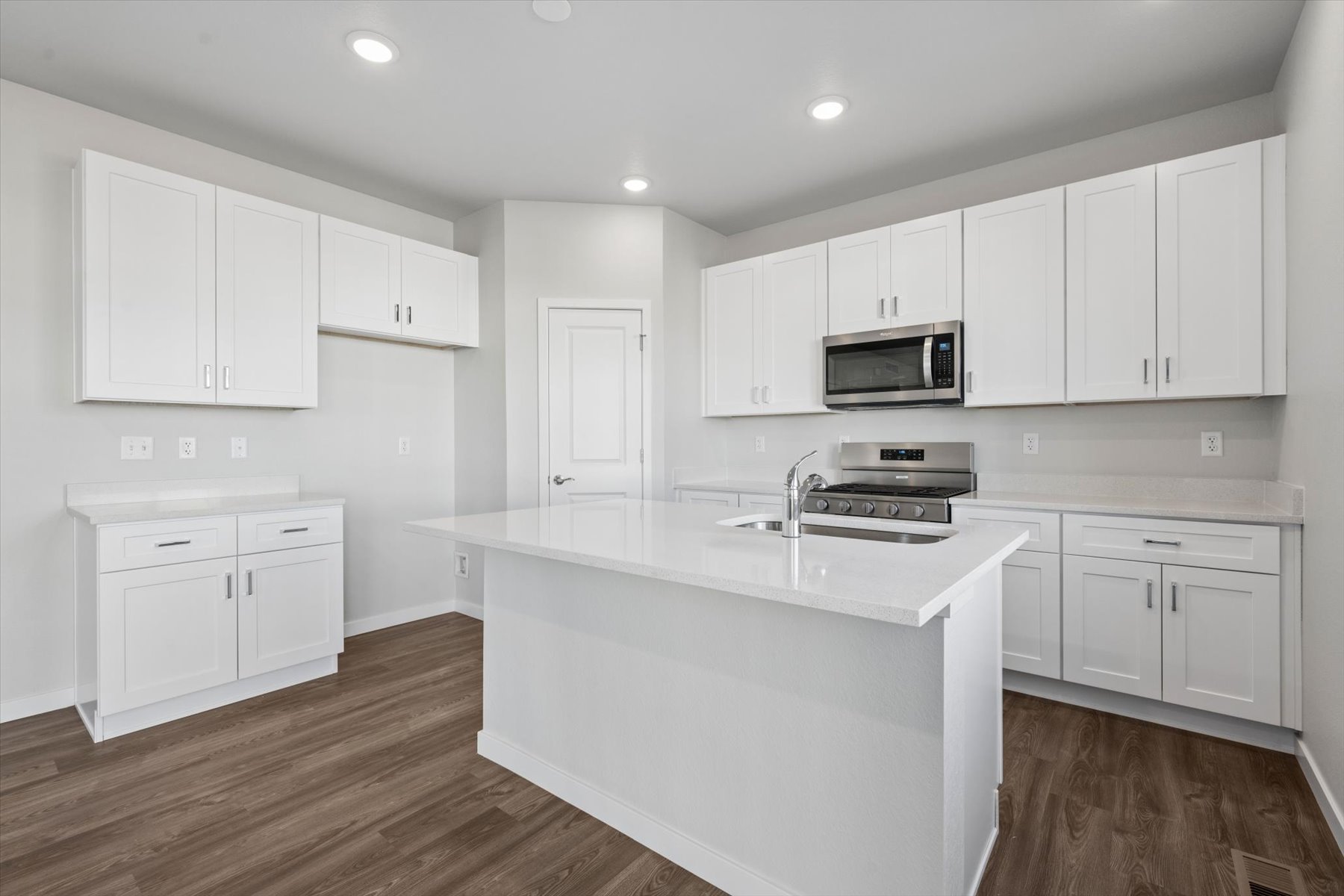 A kitchen with white cabinets.