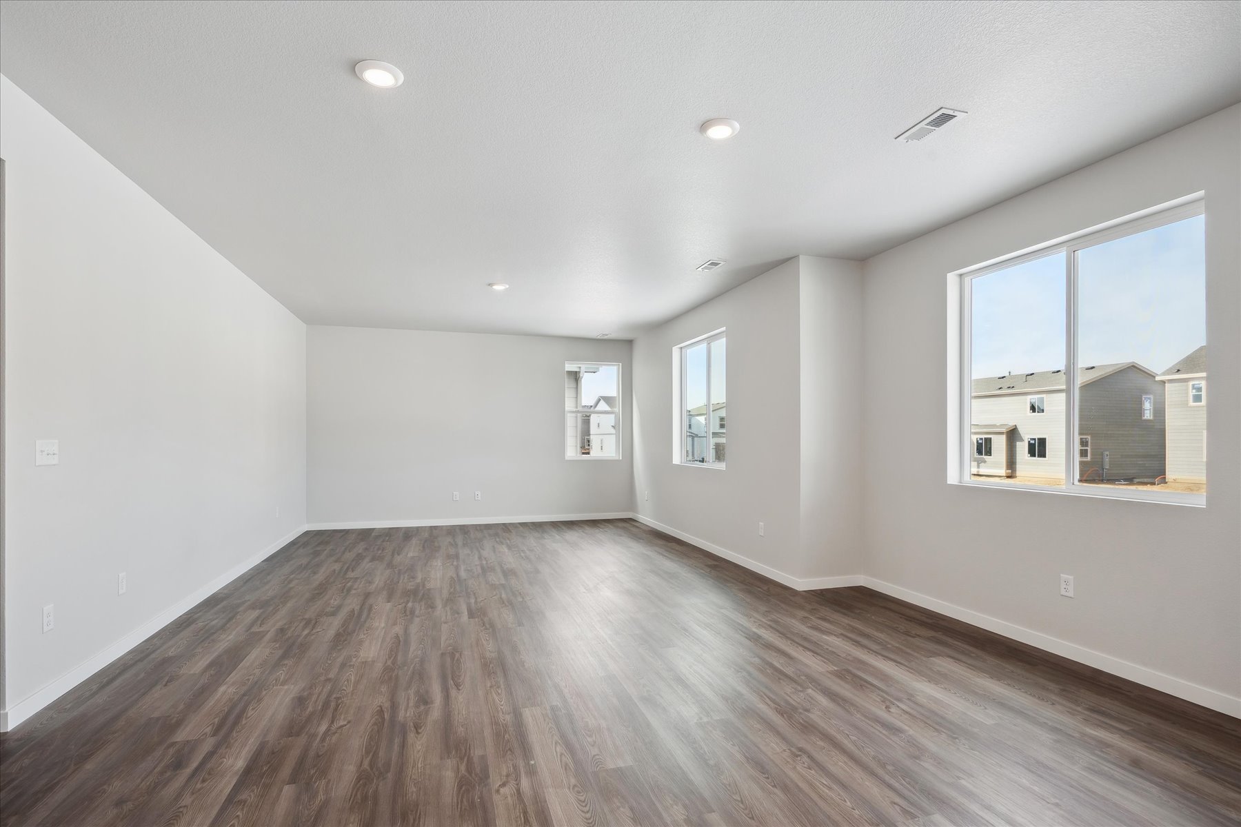 A room with a wood floor and windows.