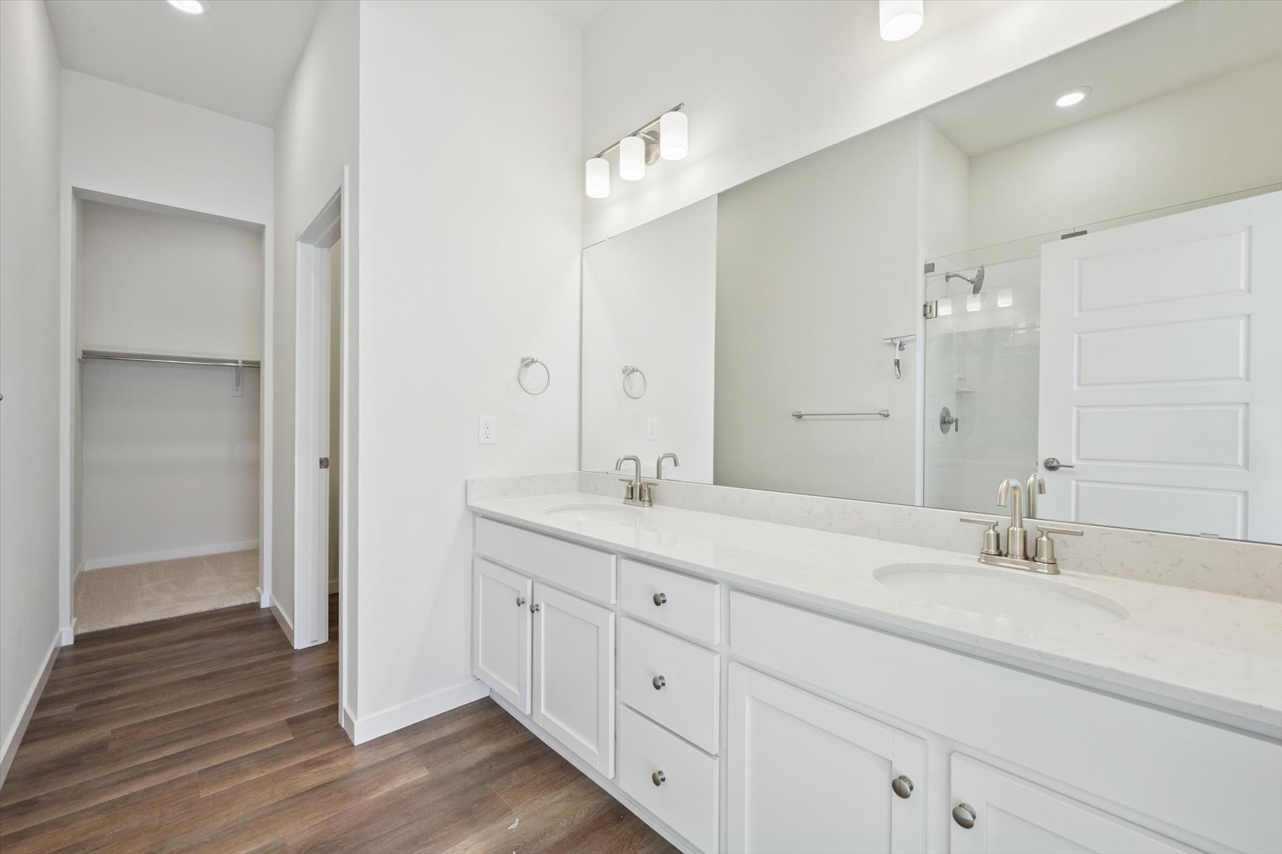 A bathroom with white cabinets.