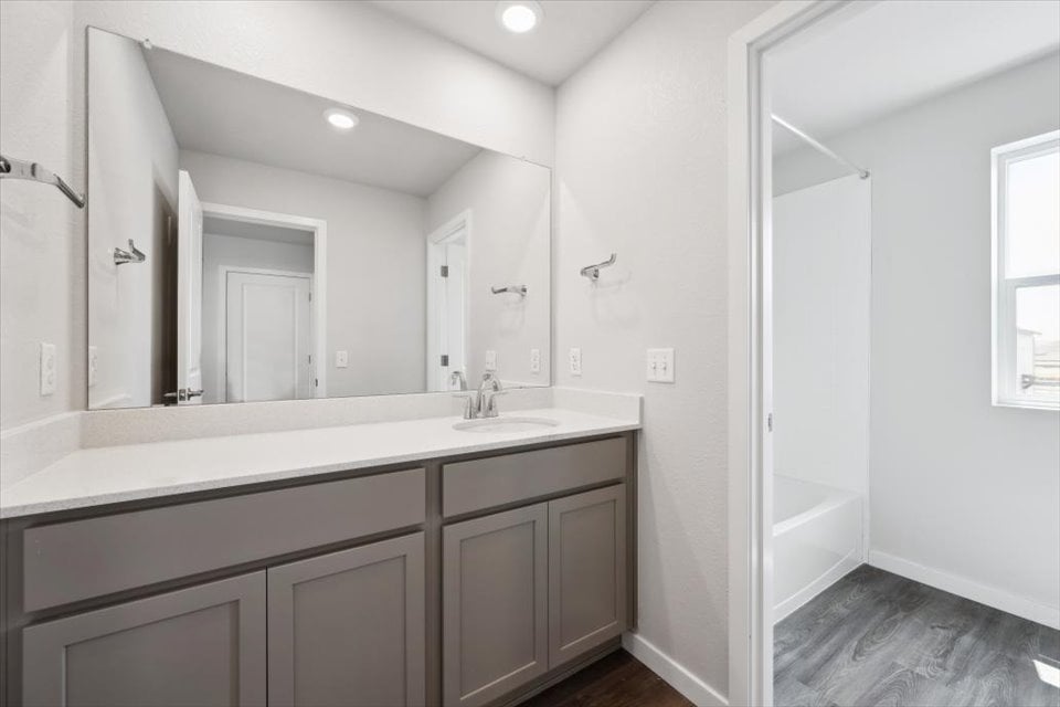 A bathroom with a sink and a shower unit.