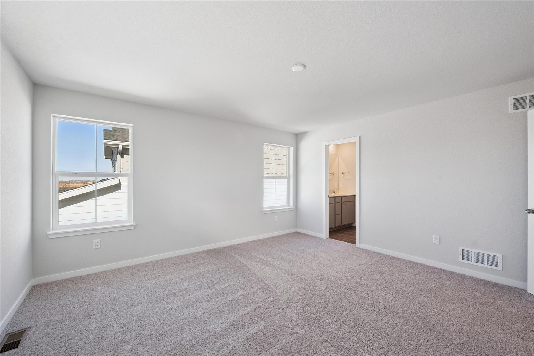 A room with a carpet and a window.