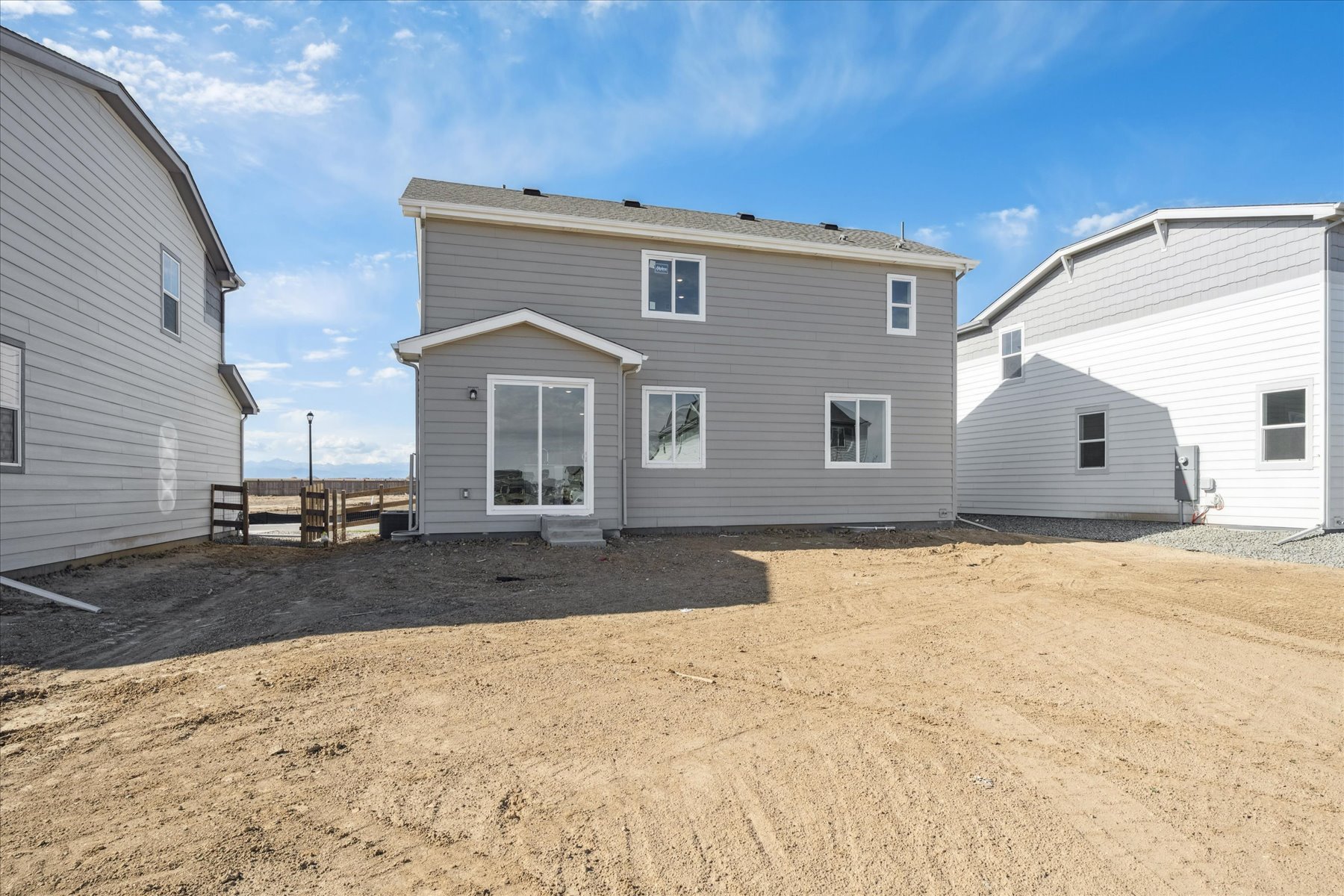 A group of buildings with a dirt field in front of them.