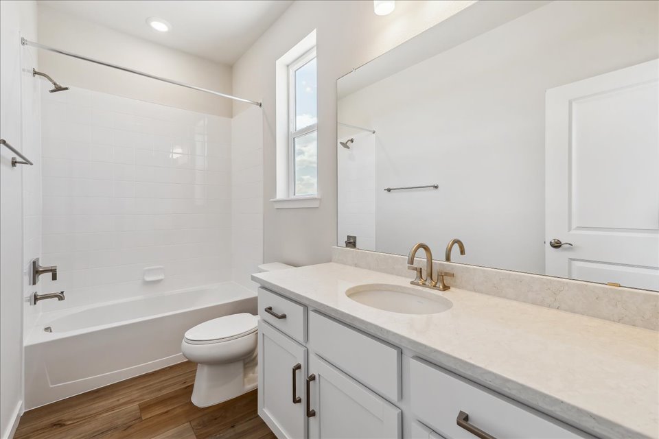 A bathroom with a tub sink and toilet.