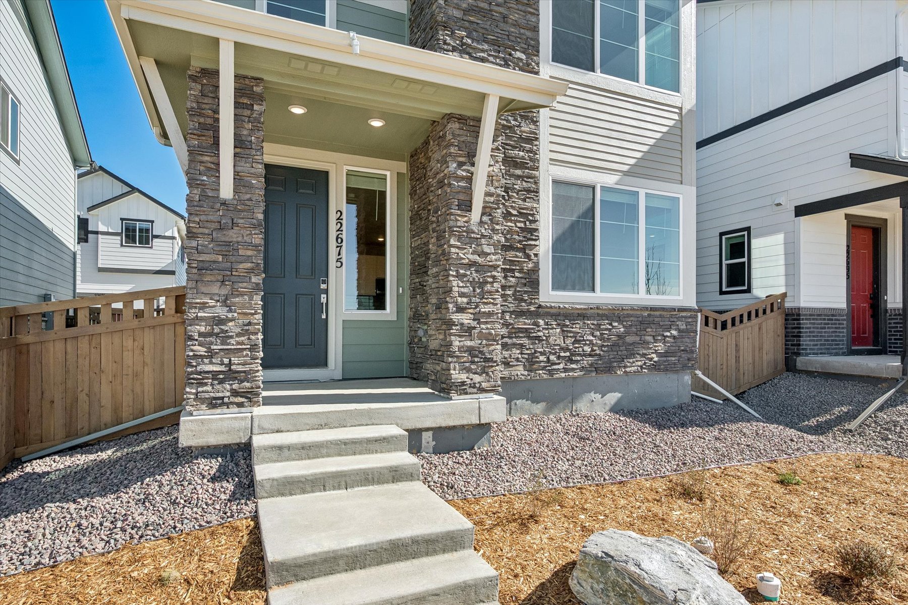 A house with a stone wall and a fence.