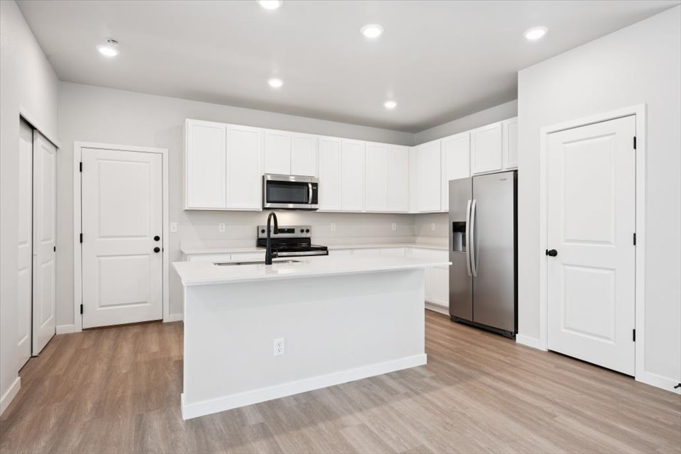 A kitchen with white cabinets.