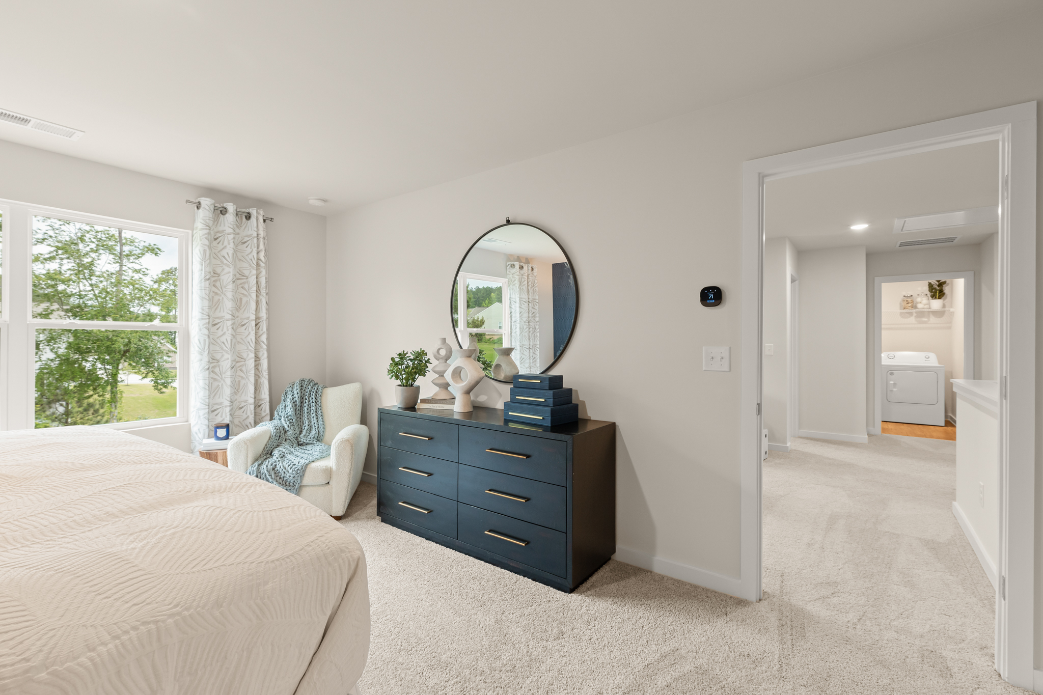 A bedroom with a bed and a mirror.