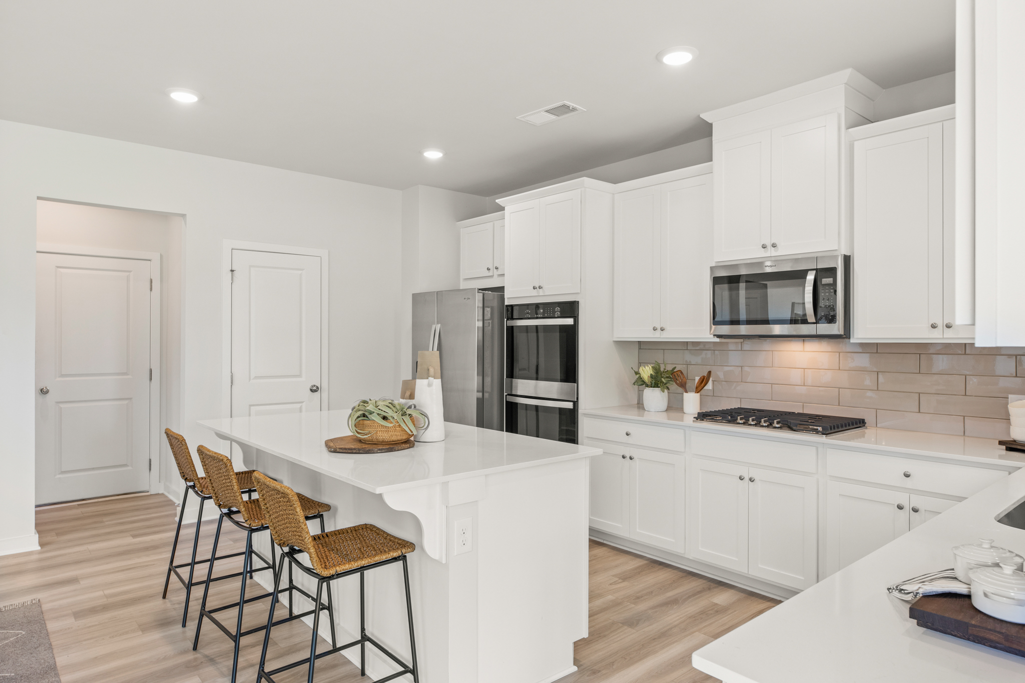 A kitchen with white cabinets.