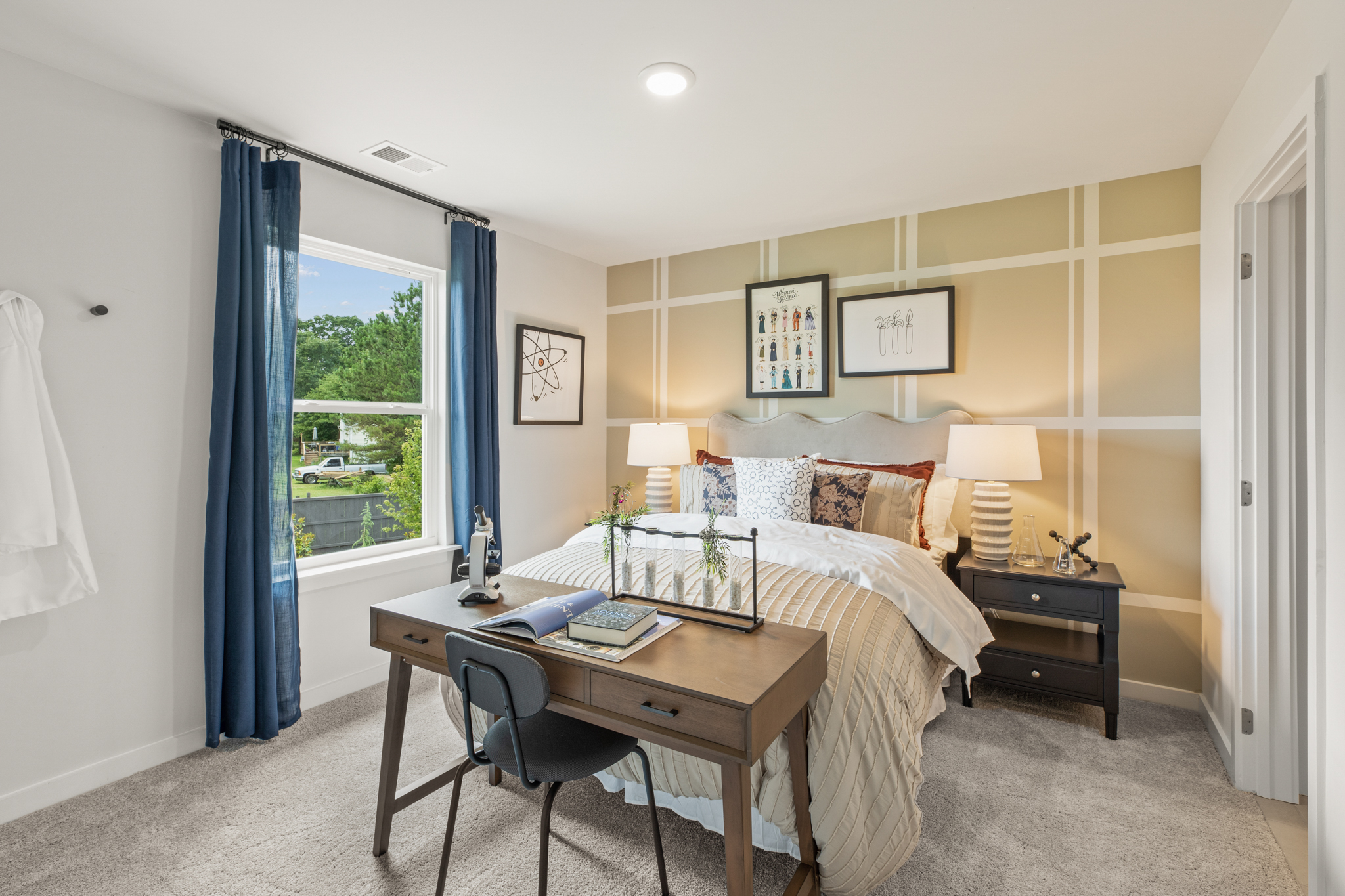 A bedroom with a bed desk and a window.