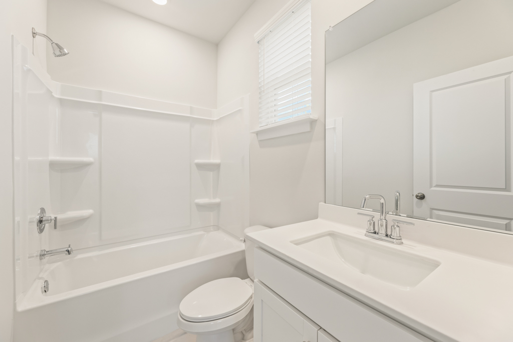 A bathroom with a tub sink and toilet.