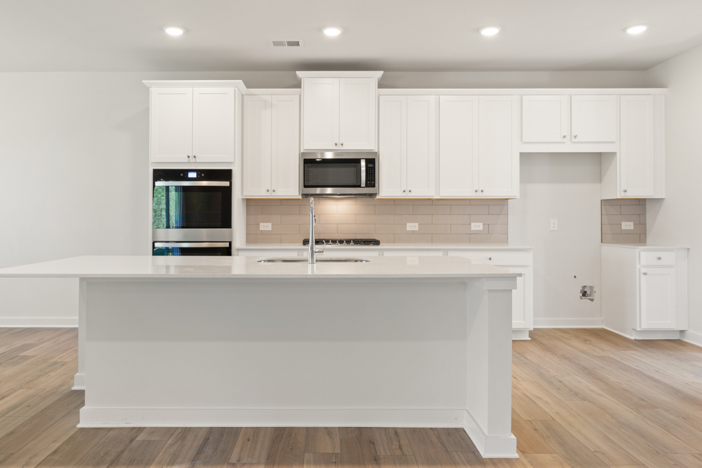 A kitchen with white cabinets.