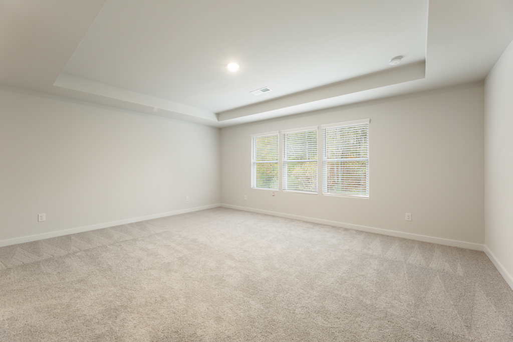 A room with a carpet and a window.