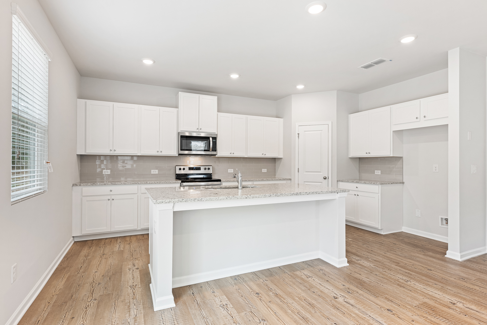 A kitchen with white cabinets.