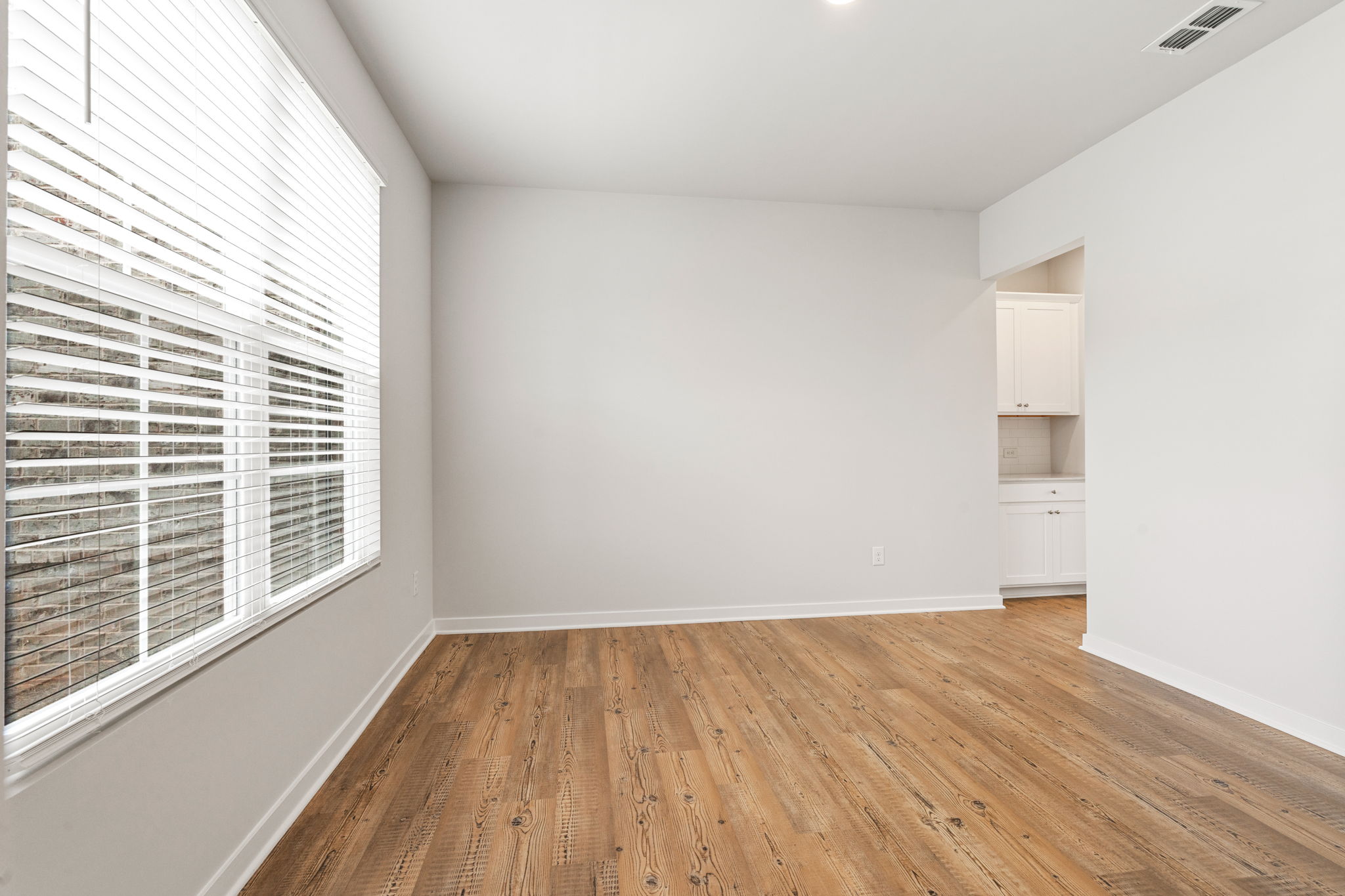 A room with a wood floor and white walls.