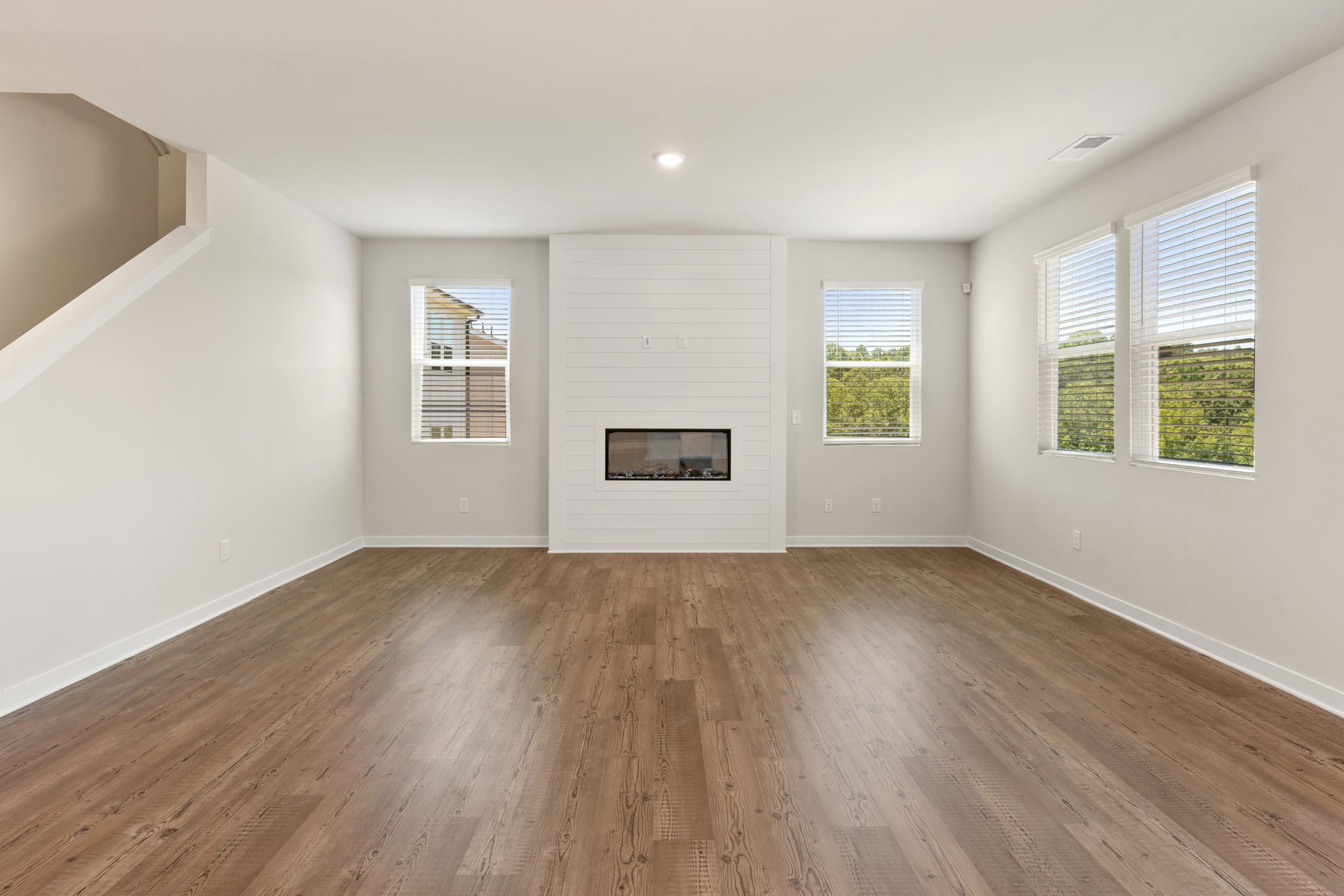A room with a wood floor and windows.