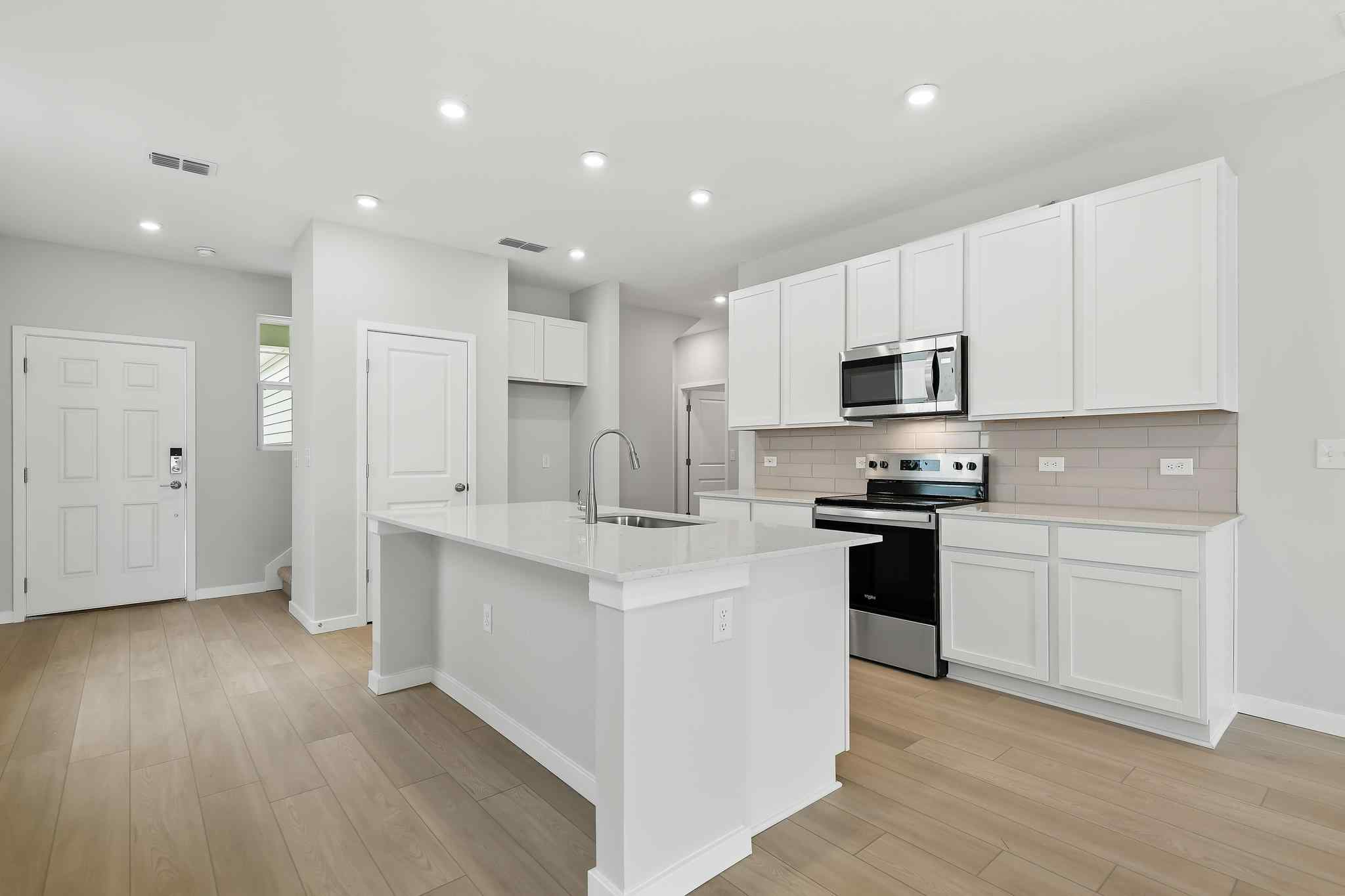 A kitchen with white cabinets.