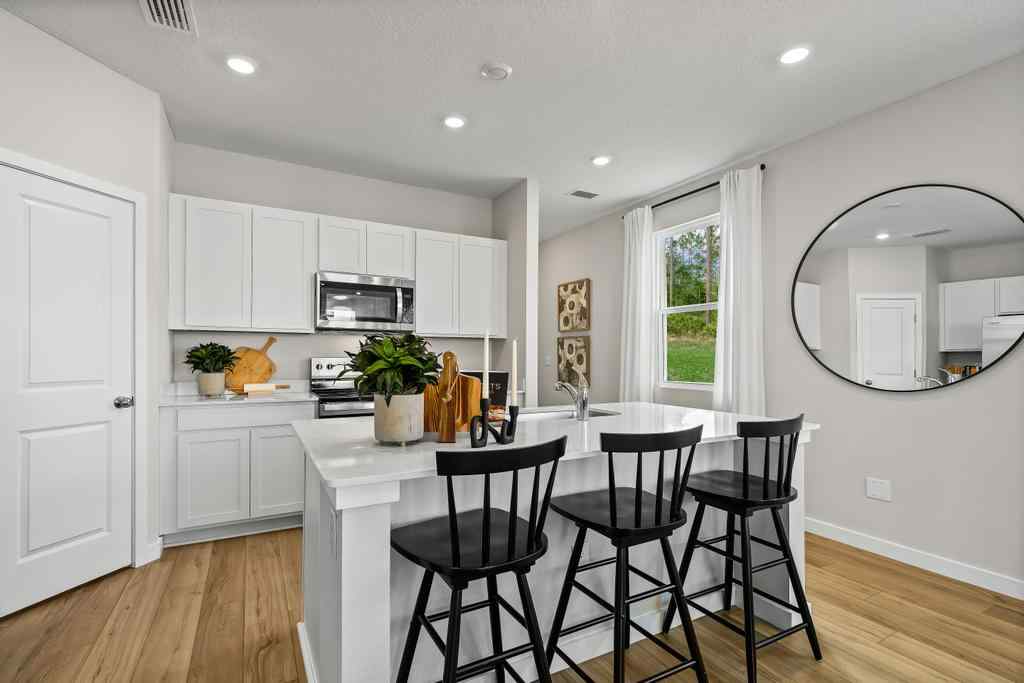 A kitchen with white cabinets.