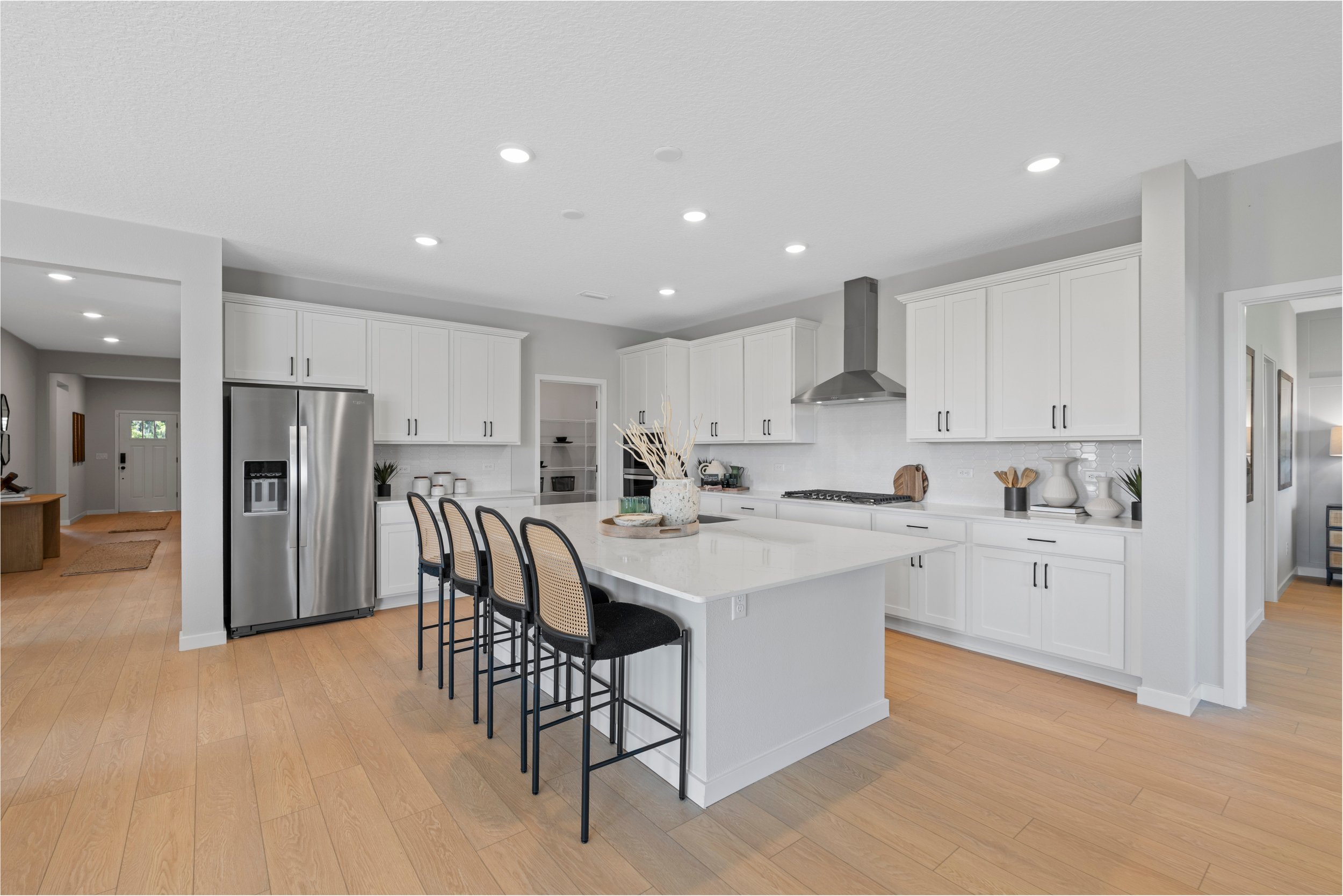 Kenai Model Home Kitchen with Island and White Cabinets at Reserve East in Flagler Beach
