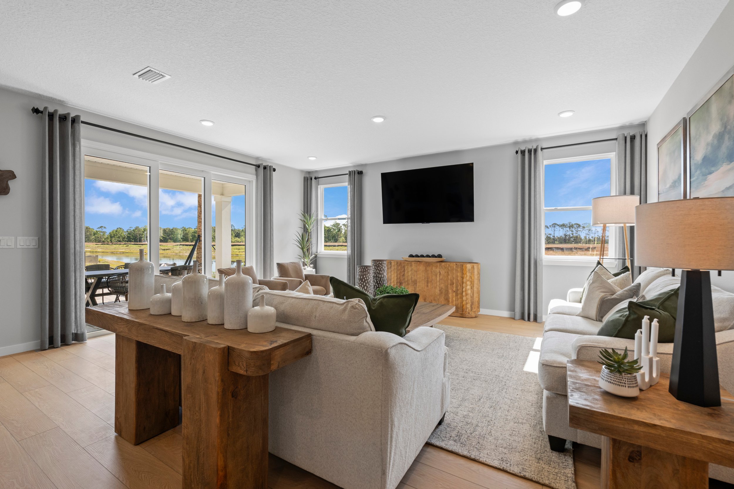 Kenai Model Home Living Room with Large Patio Doors at Reserve East in Flagler Beach