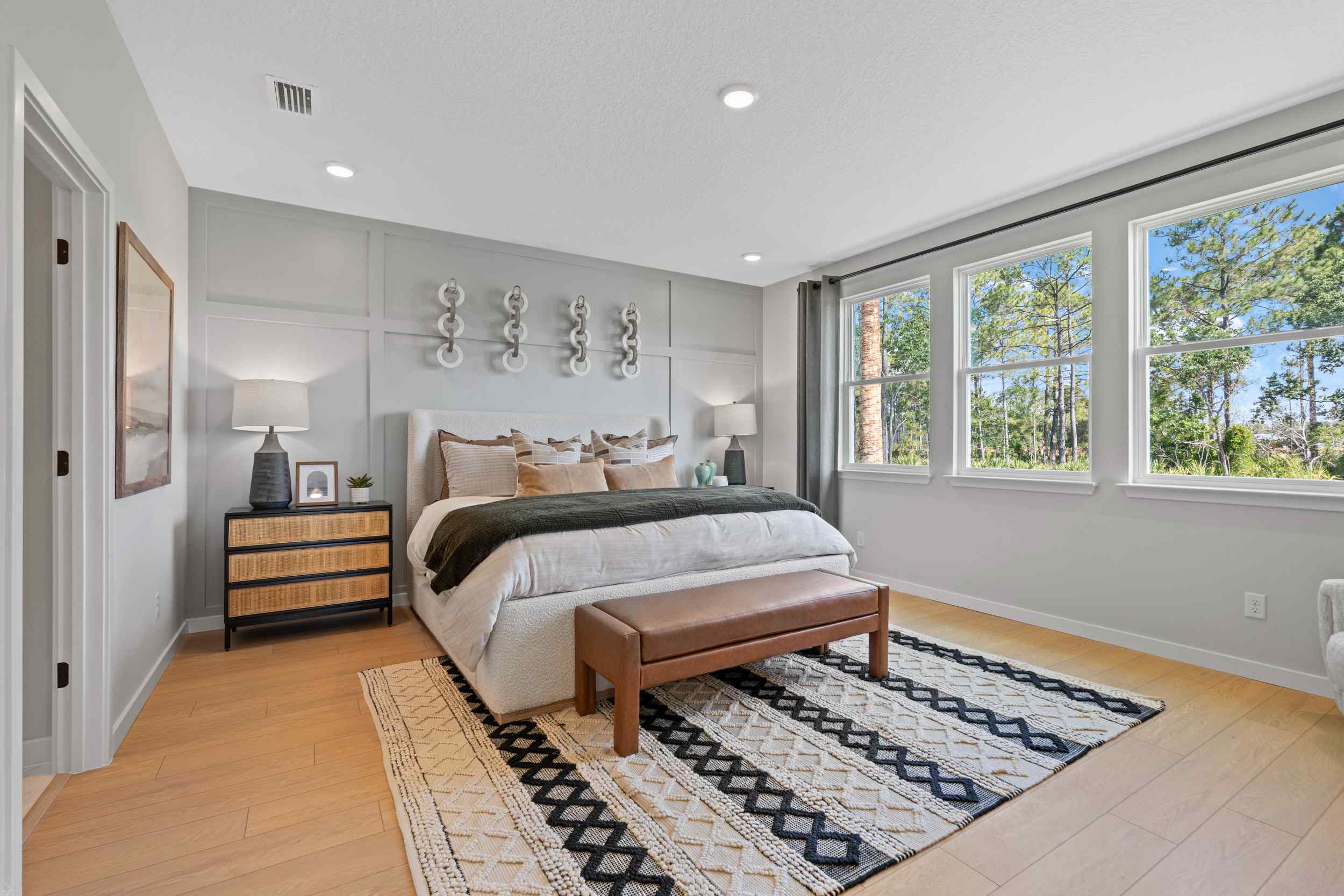 Kenai Model Home Large Primary Bedroom with King Bed and Three Windows at Reserve East in Flagler Beach