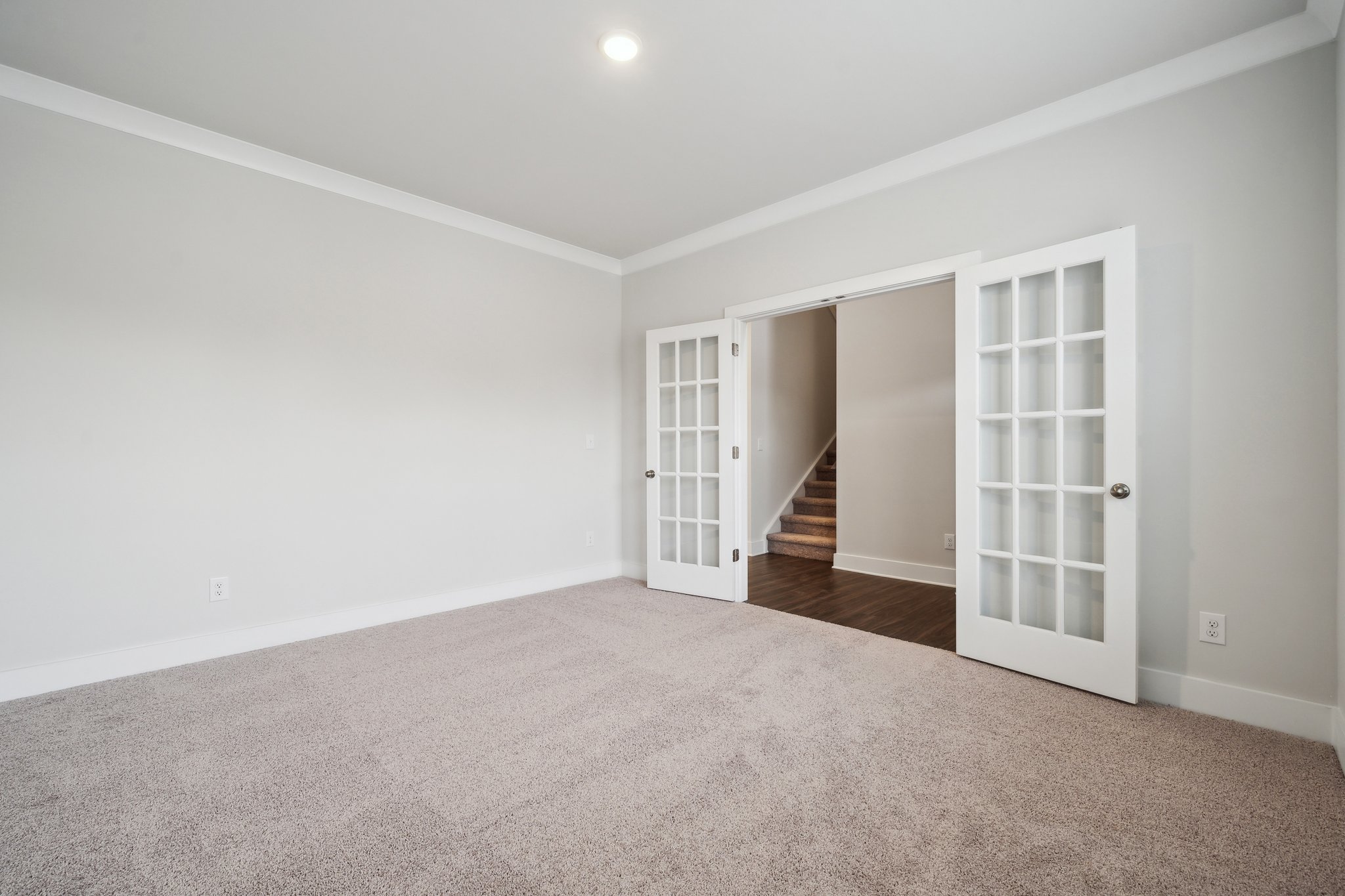 A room with a staircase and a door.