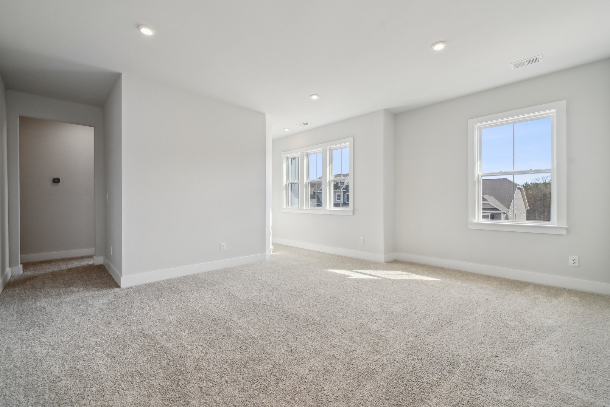 A room with a carpet and windows.