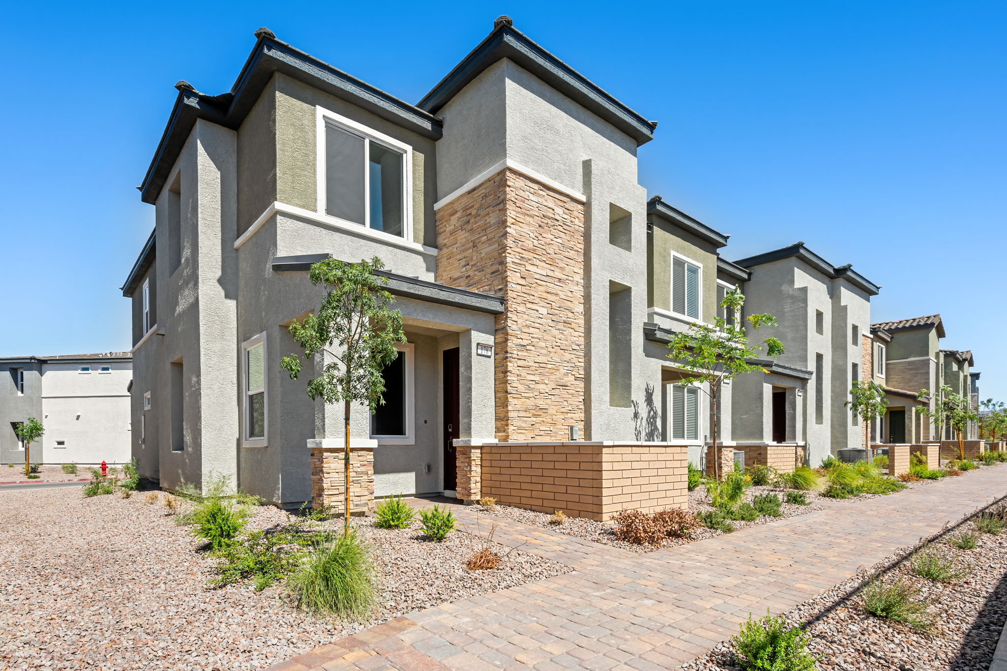 A brick building with trees and bushes.