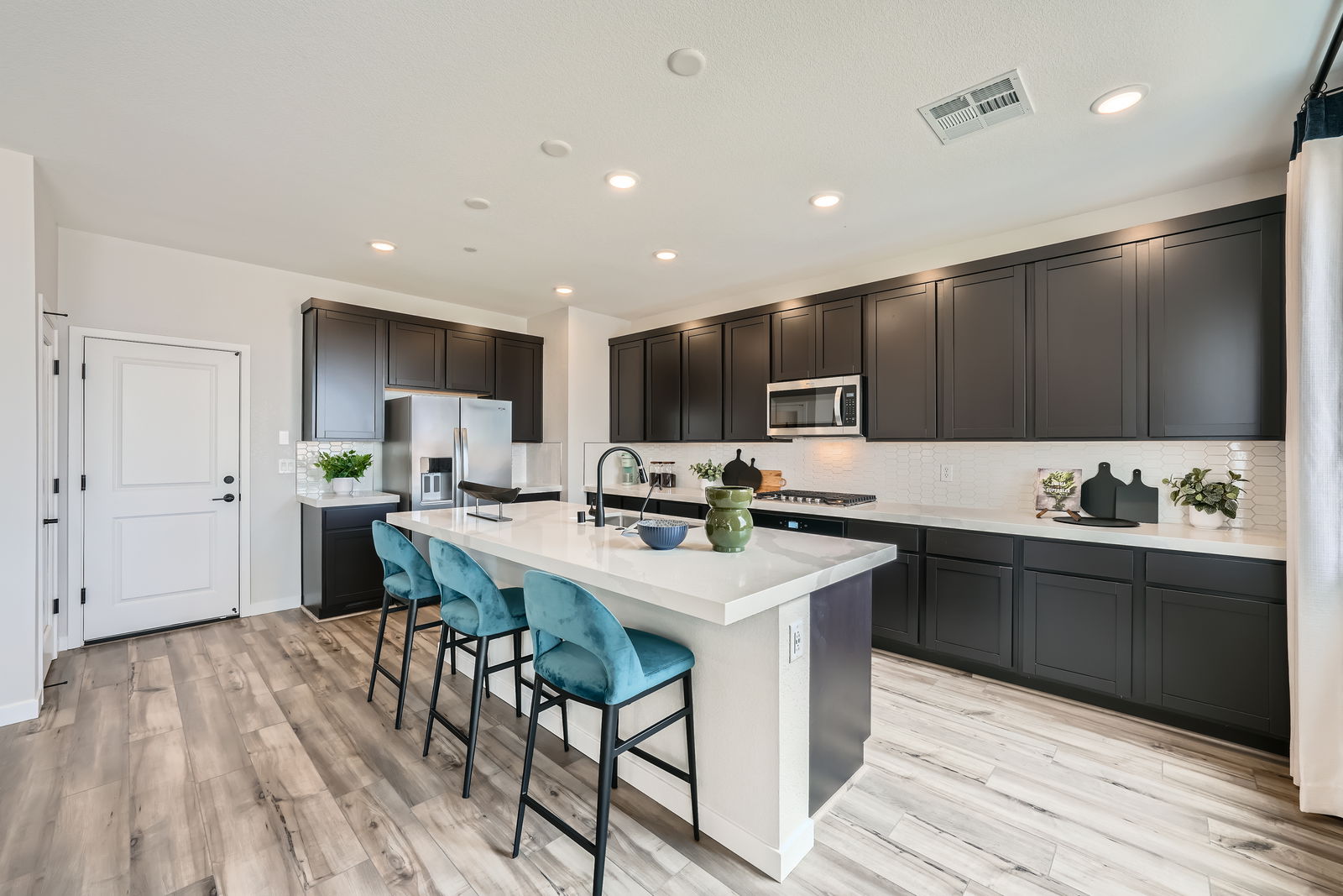 A kitchen with a bar and chairs.