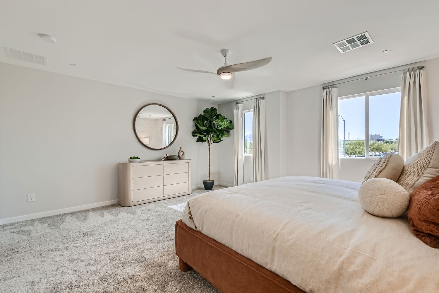 A bedroom with a bed and a mirror.