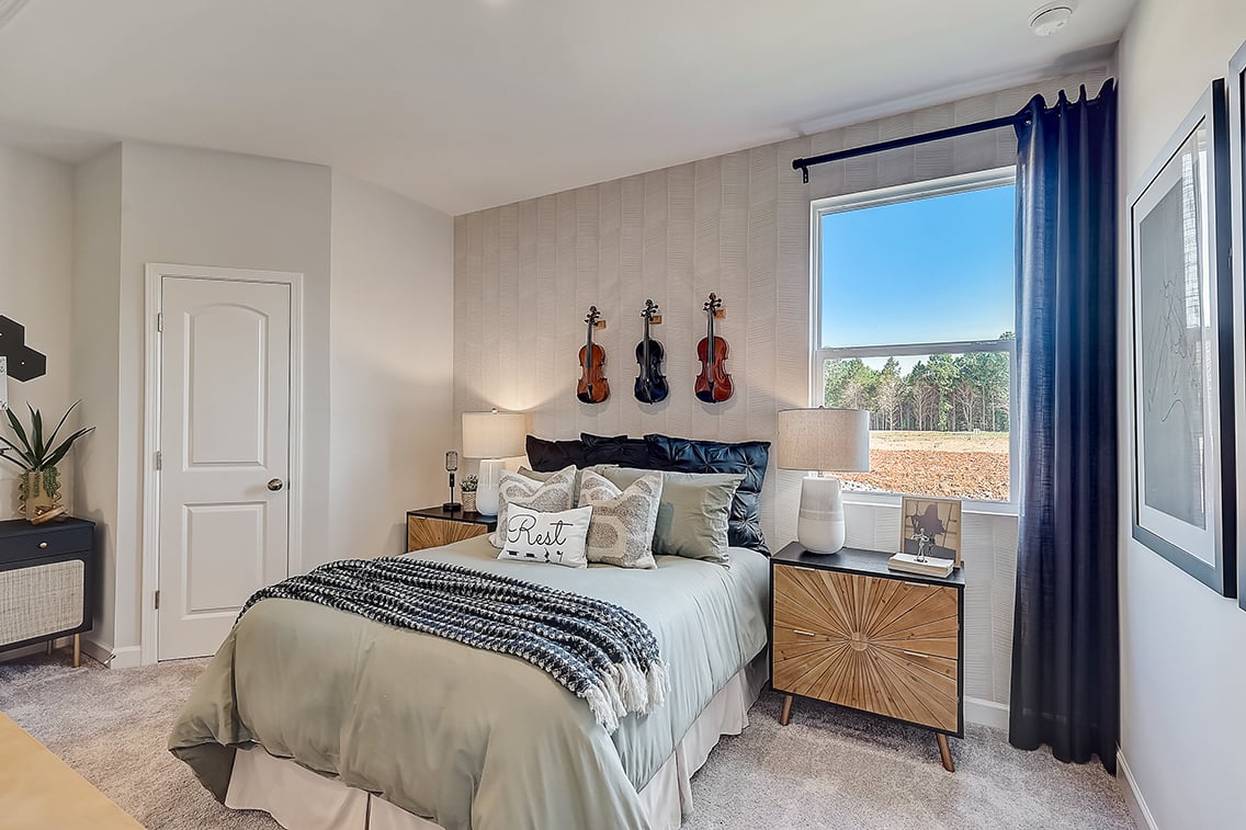 A bedroom with a large window.