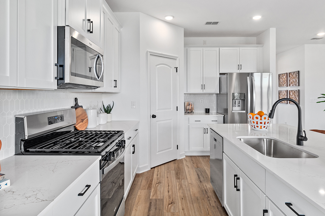 A kitchen with white cabinets.