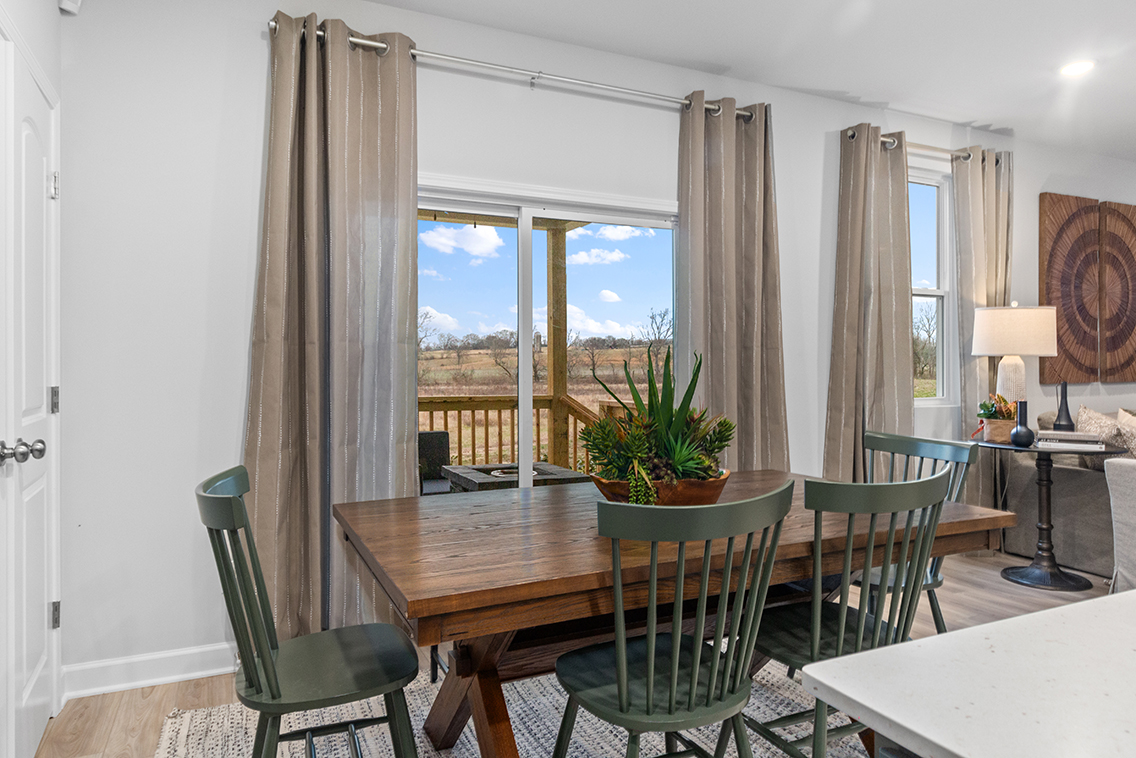A dining room table with chairs and a view of the city.