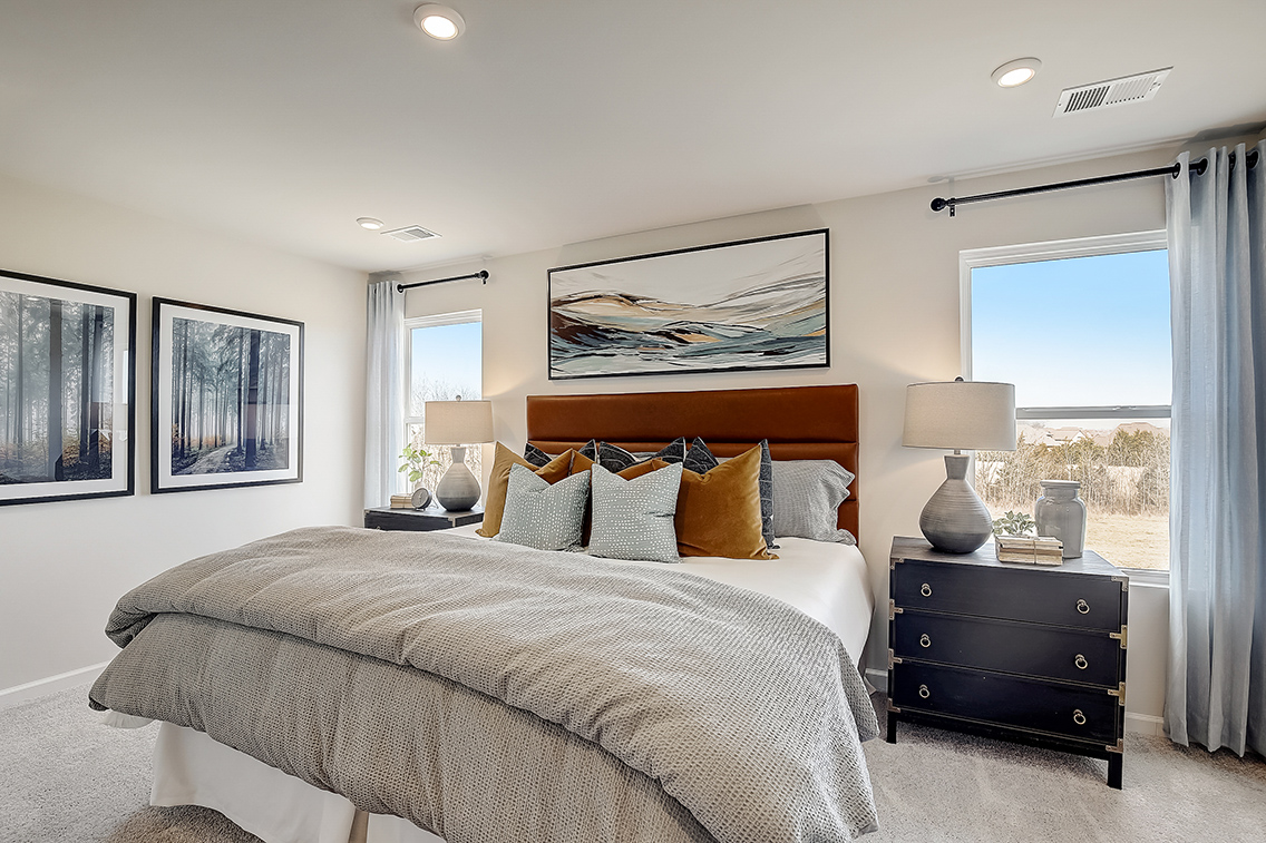 A bedroom with a bed and lamps.