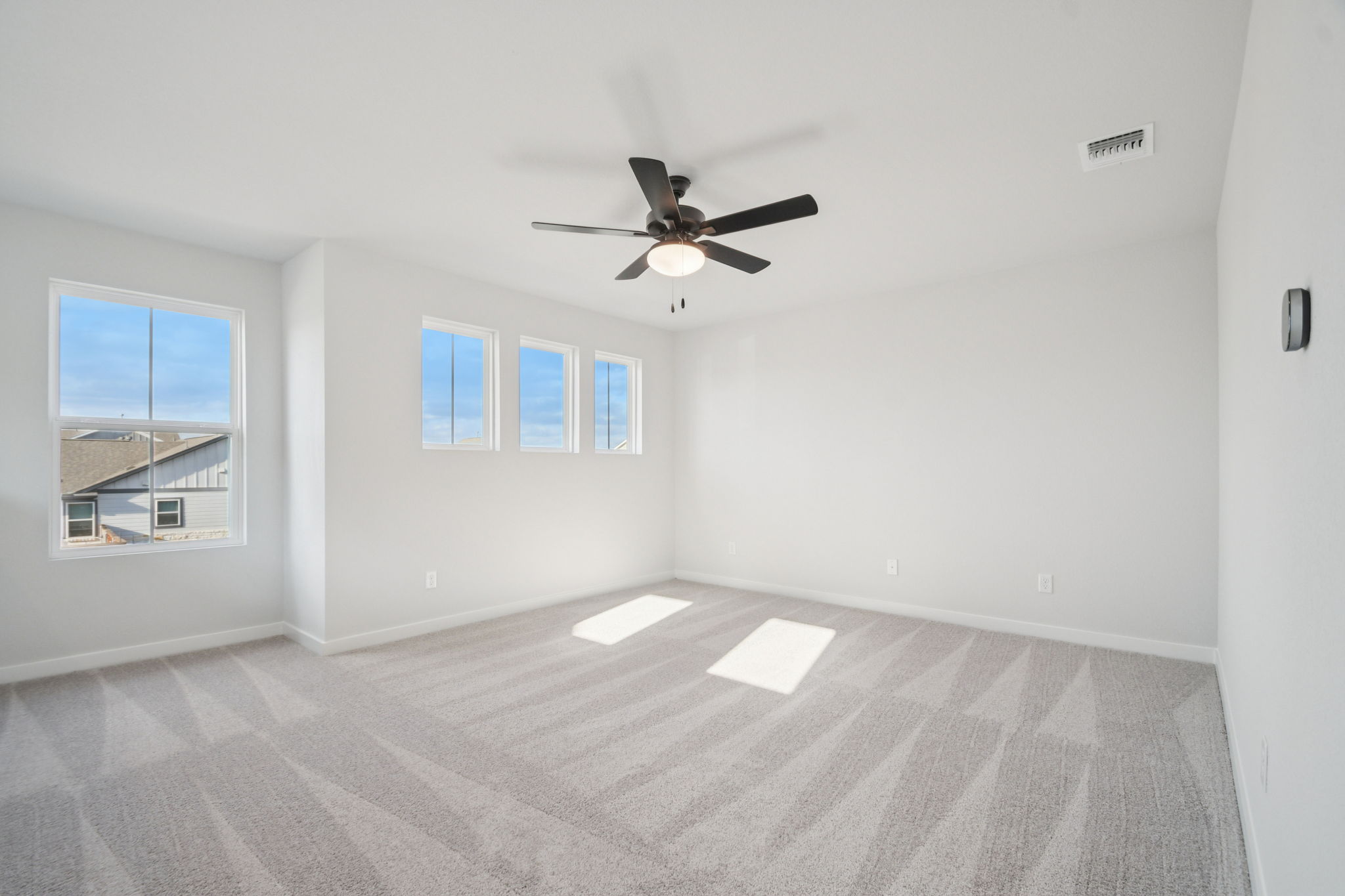 A room with a ceiling fan and a window.