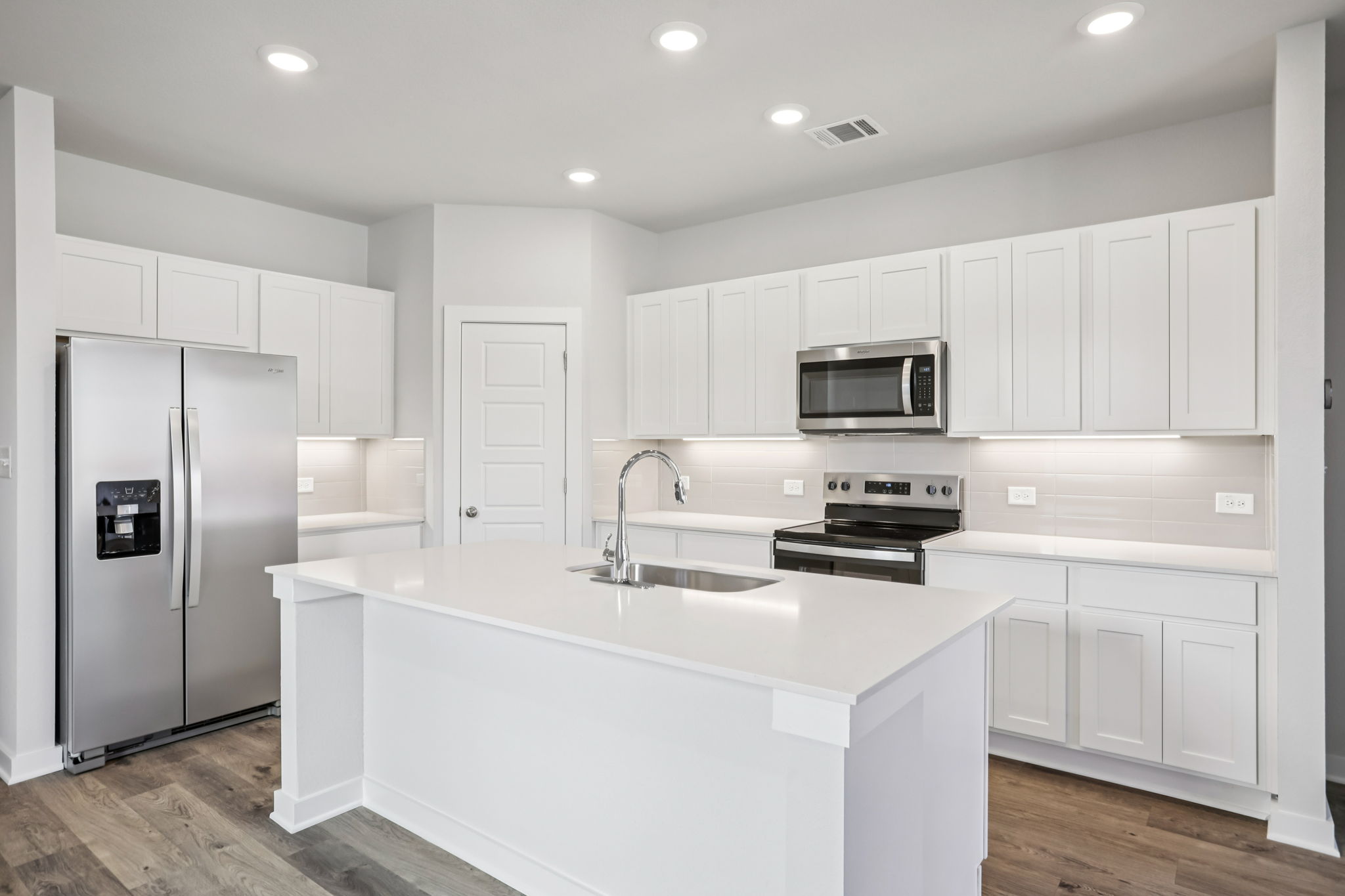 A kitchen with white cabinets.