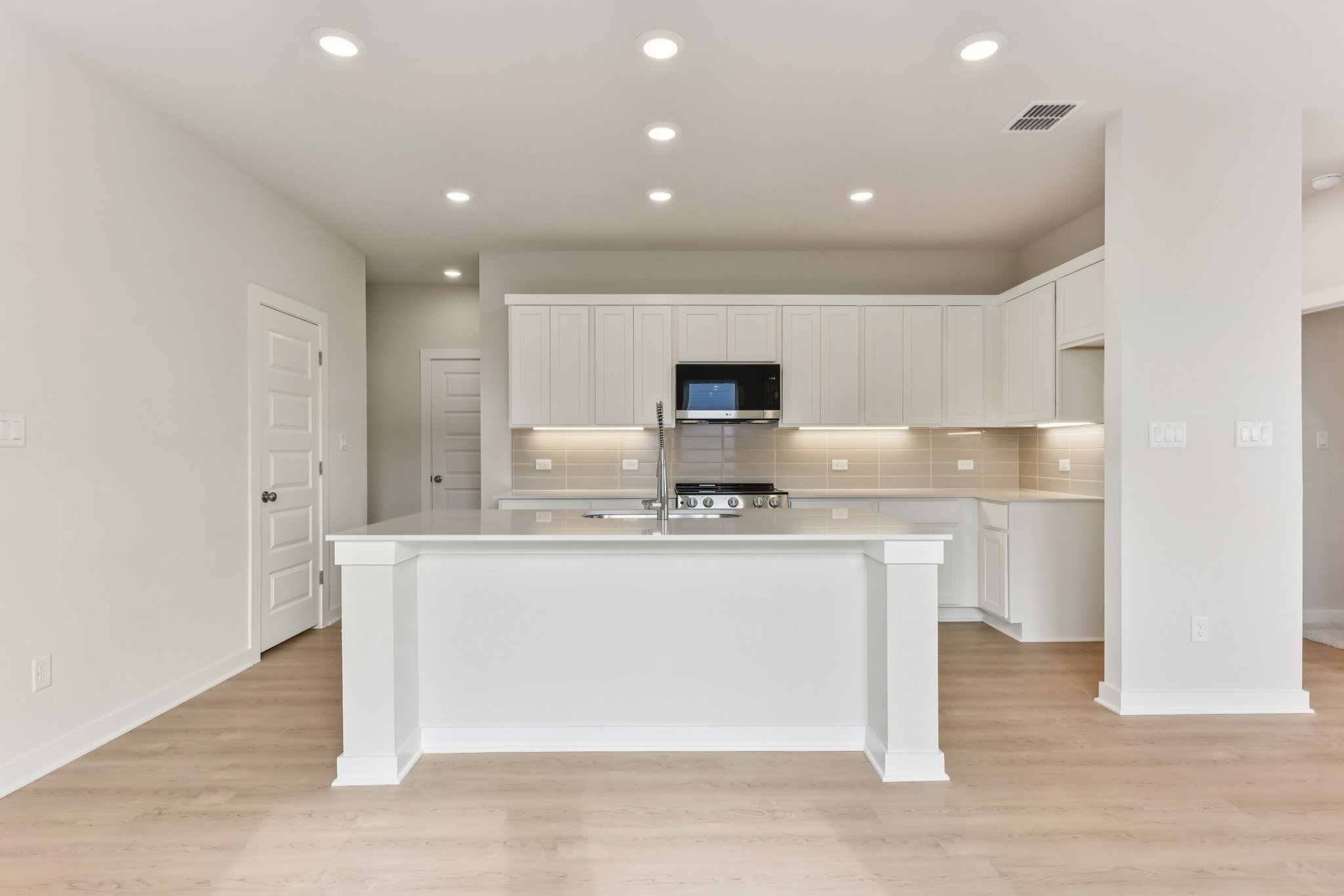 A kitchen with white cabinets.