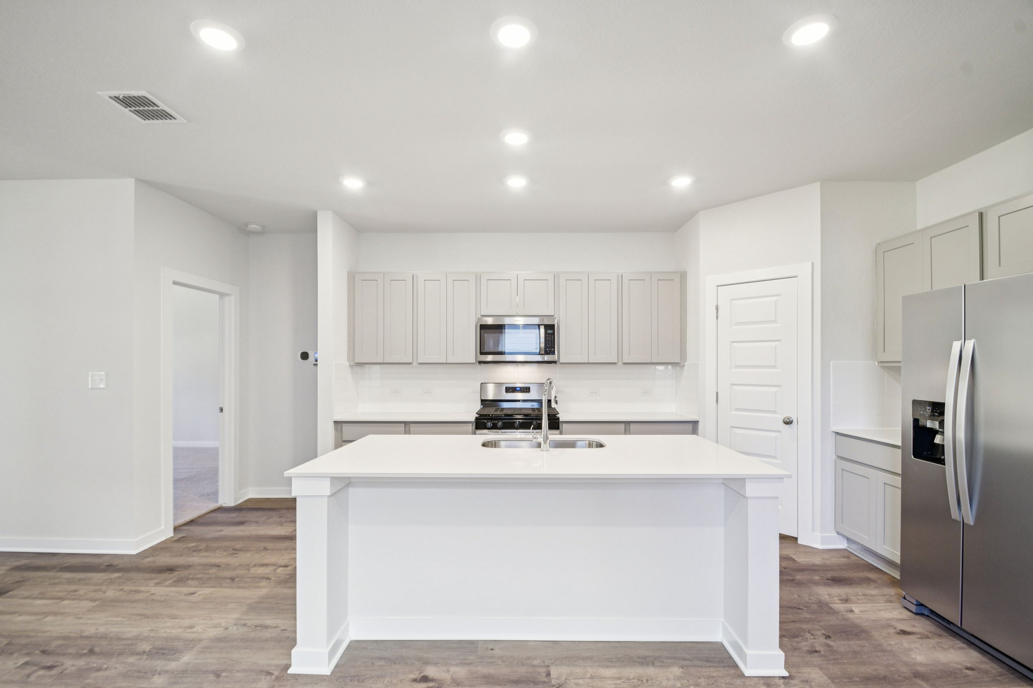 A kitchen with white cabinets.